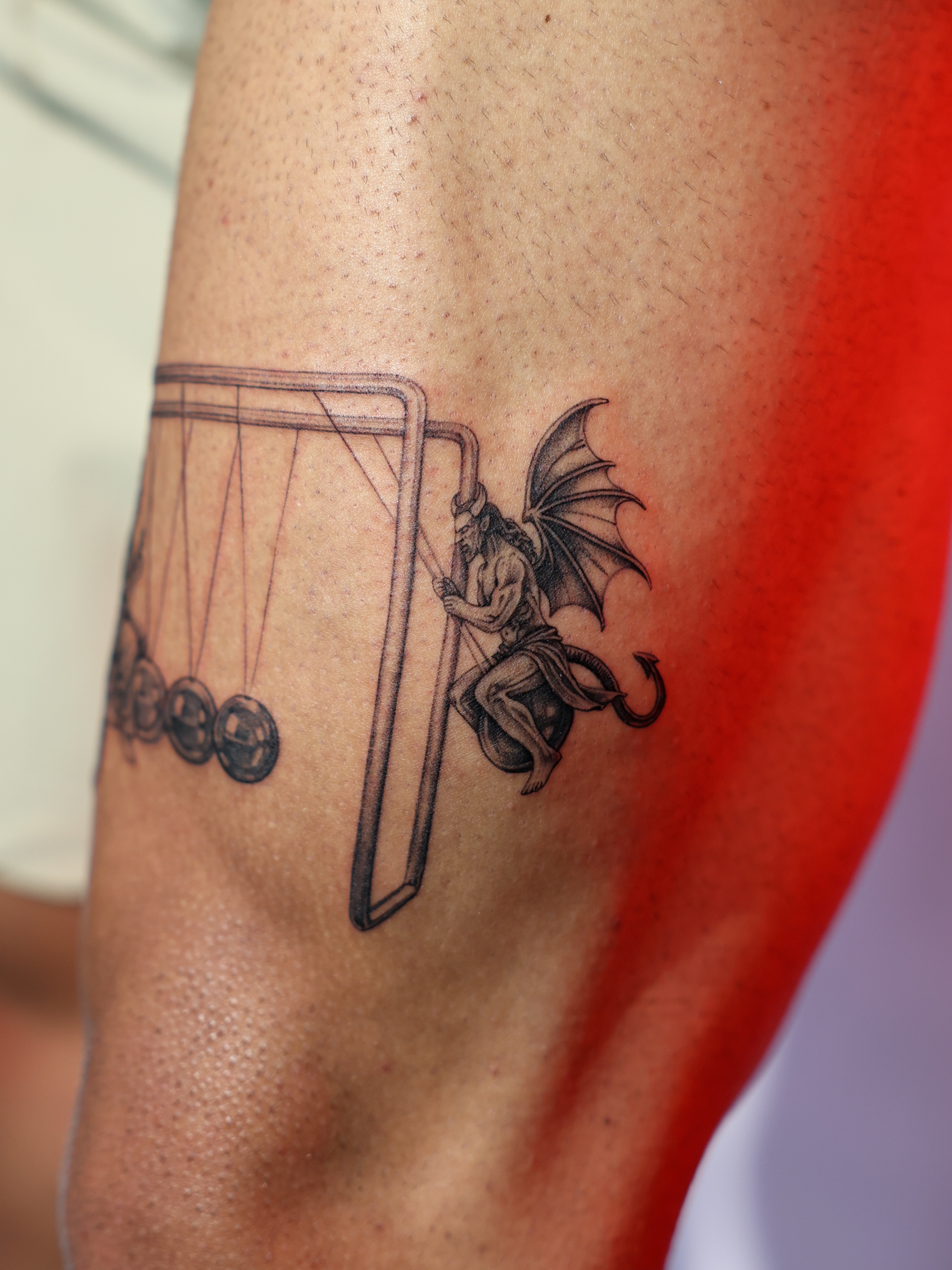 Newton's cradle with devil realism tattoo on the forearm by Tiny