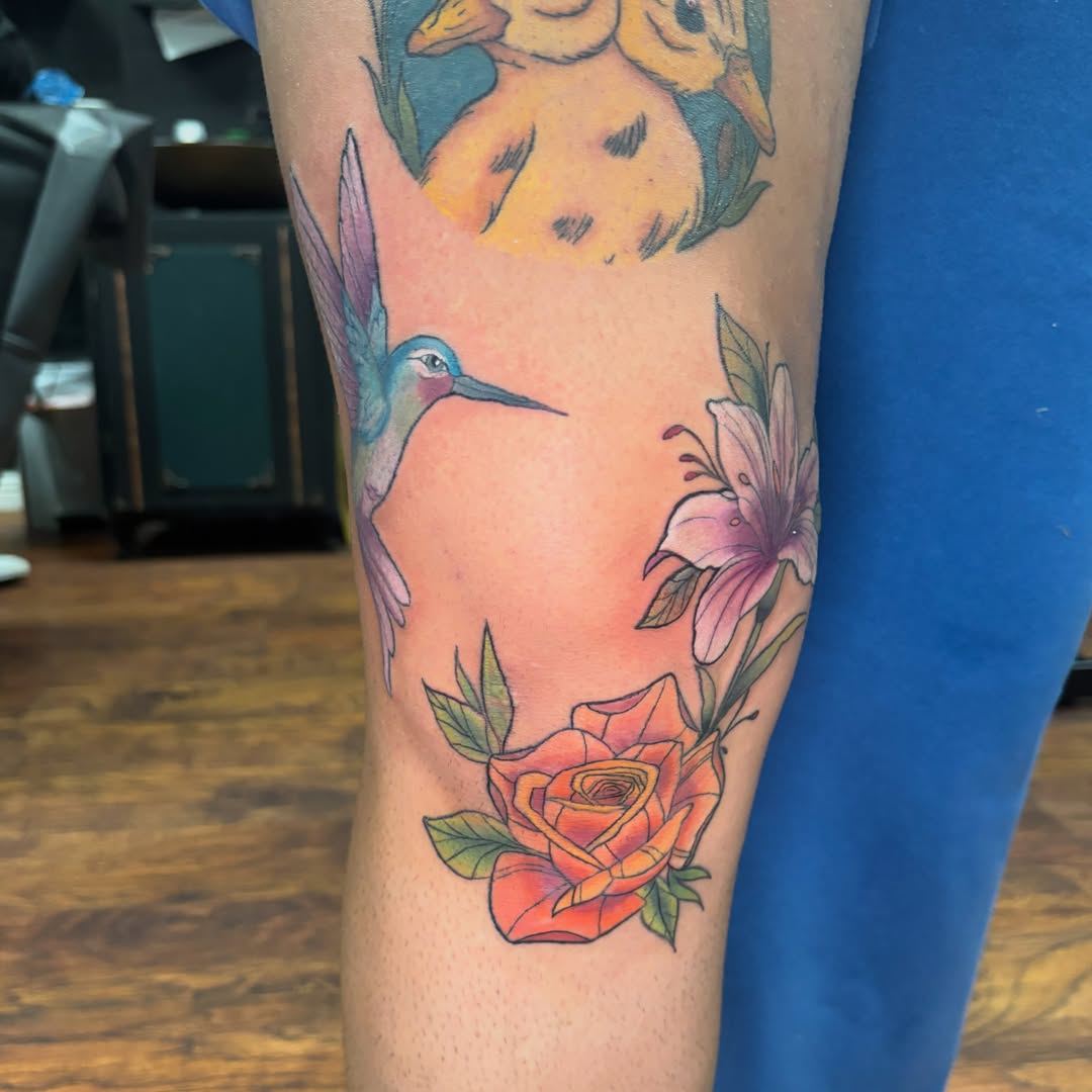 Hummingbird and flowers watercolor tattoo on the forearm by Emma ๐