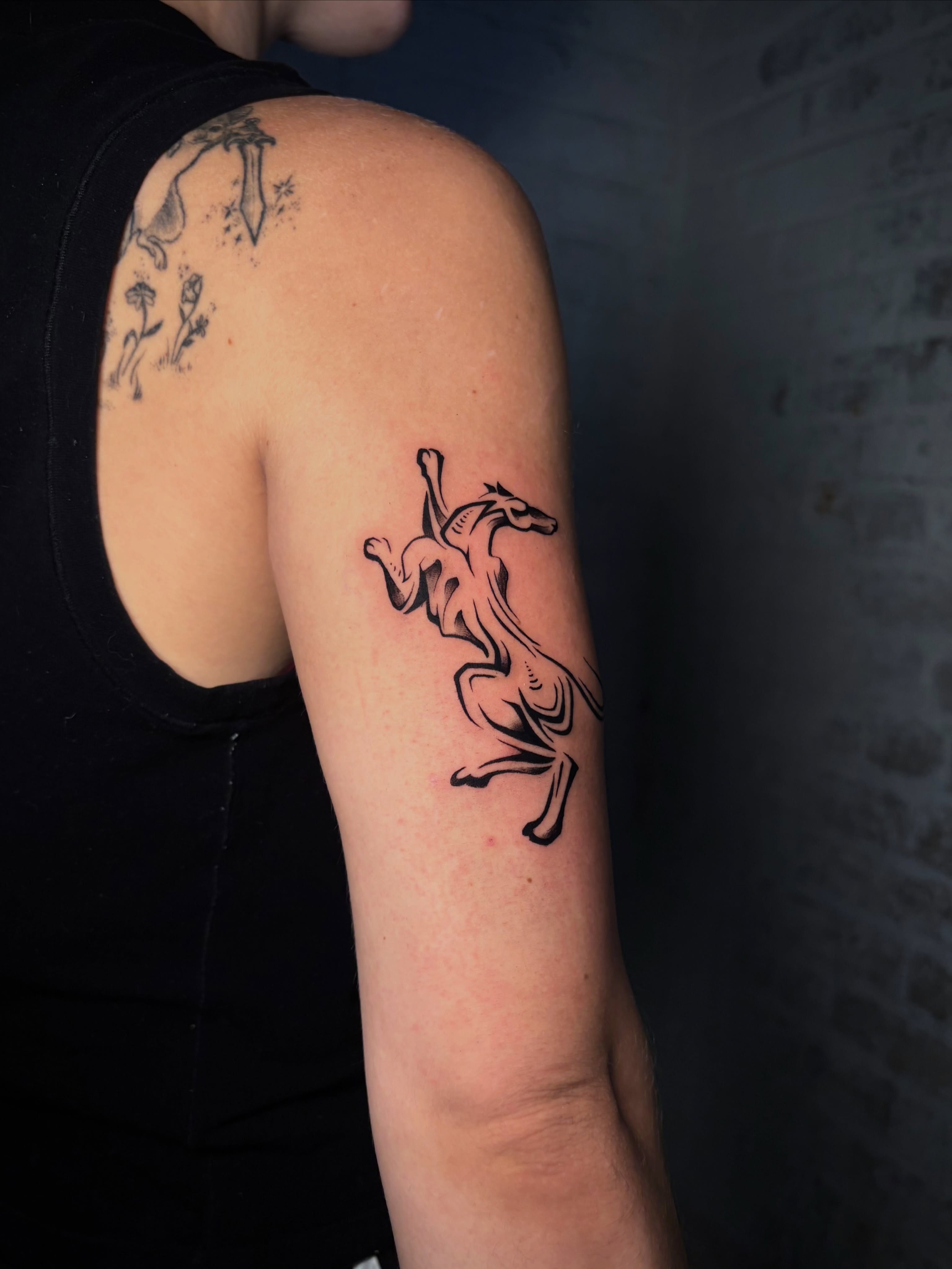 Horse black and grey tattoo on the forearm by Musa Selman