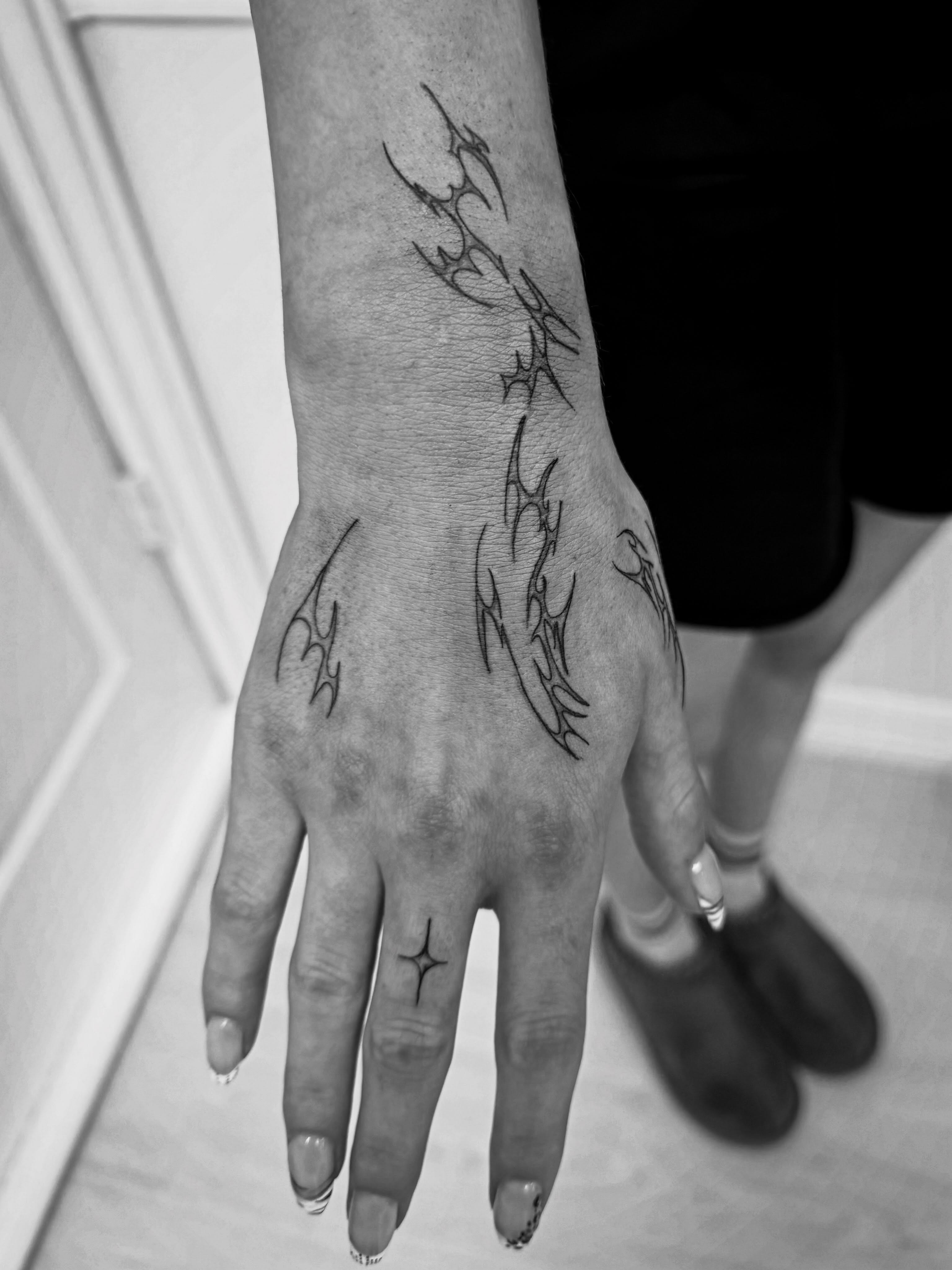 Abstract flame tribal tattoo on the hand by Taylor Johnson
