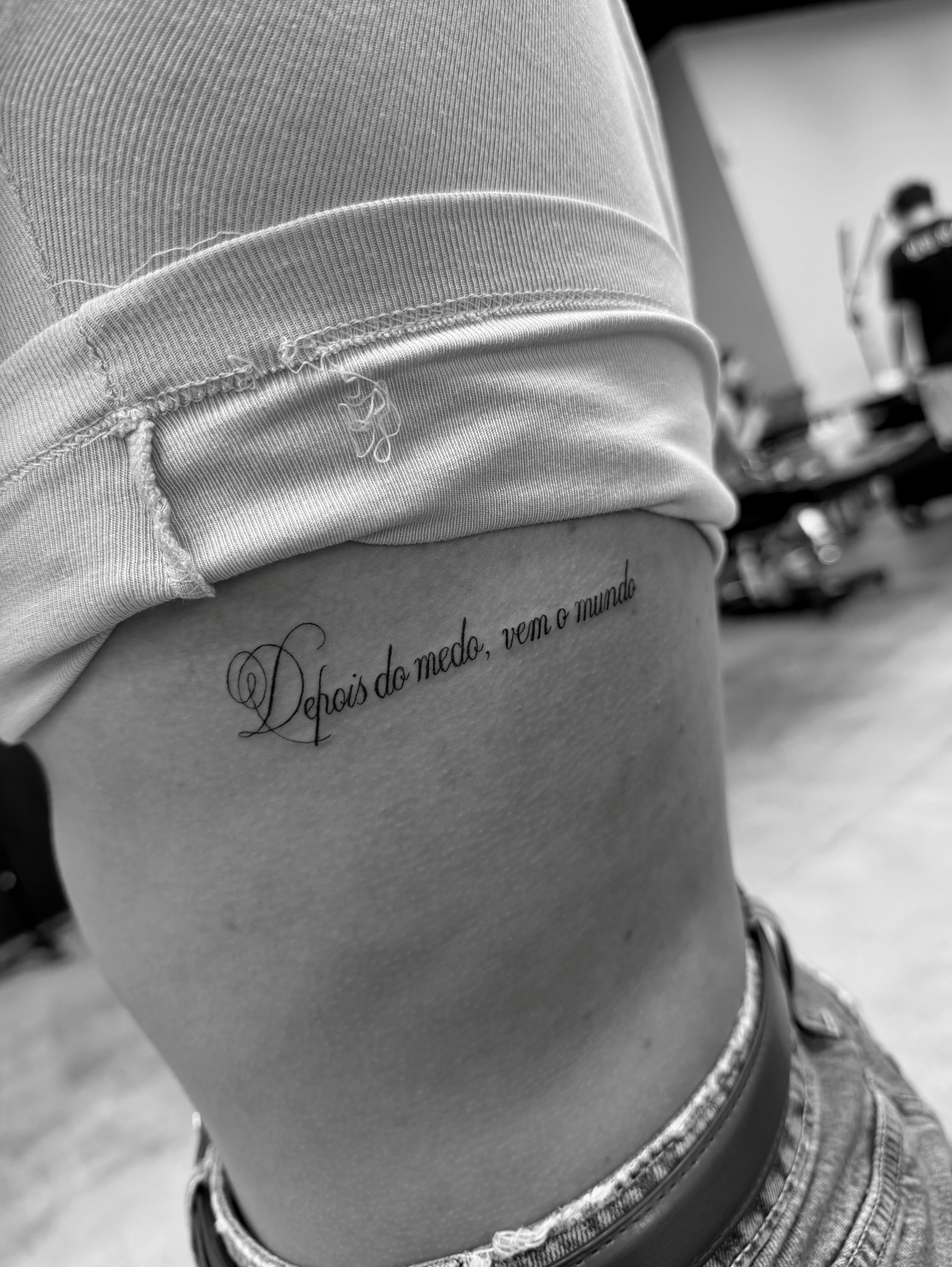 Depois do medo, vem o mundo lettering script tattoo on the thigh by Lina Valentina, New York, New York