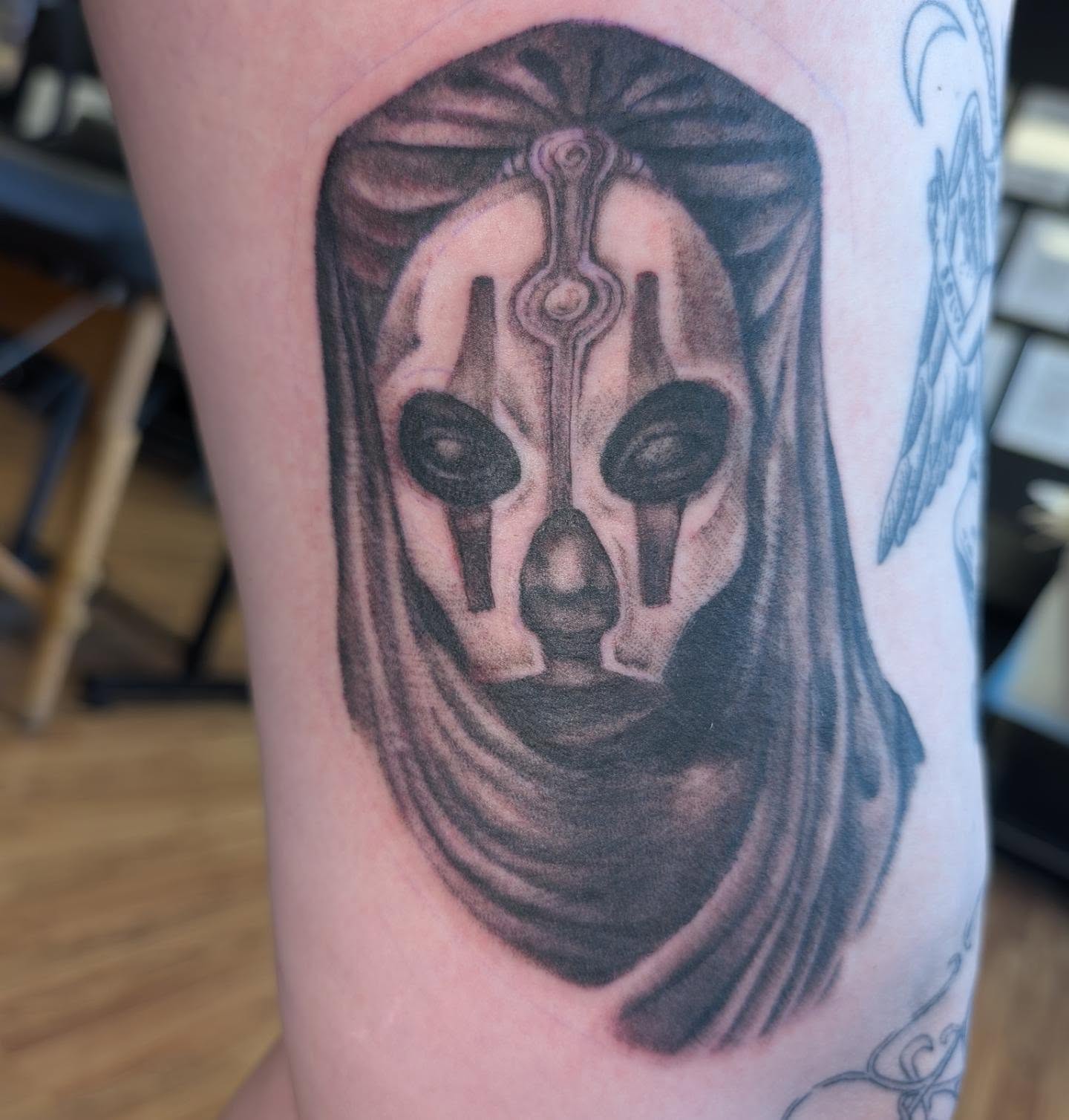 Mask black and grey tattoo on the forearm by Chad Nuber