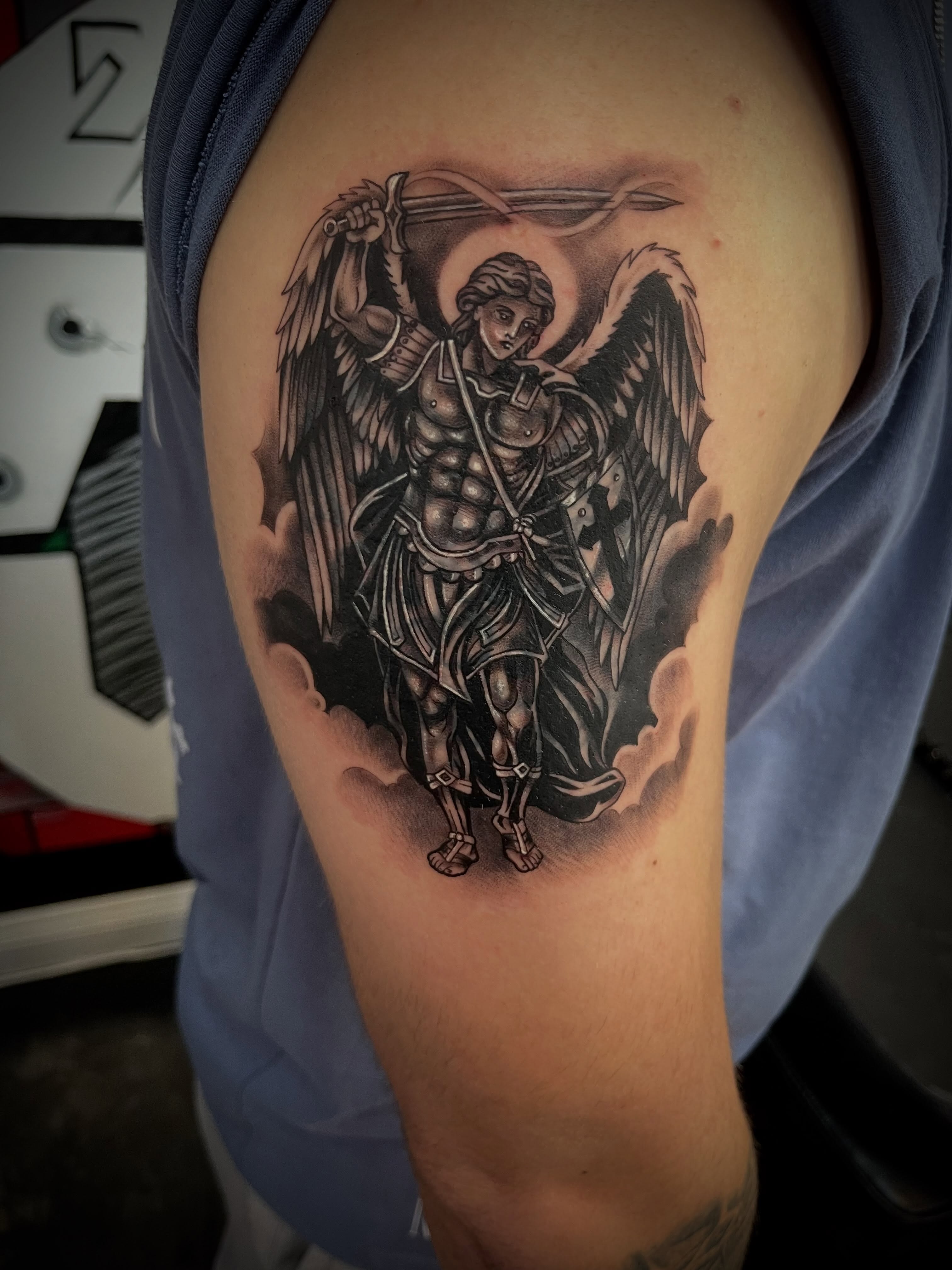 Angel with sword black and grey tattoo on the shoulder by Kwete Tatuajes