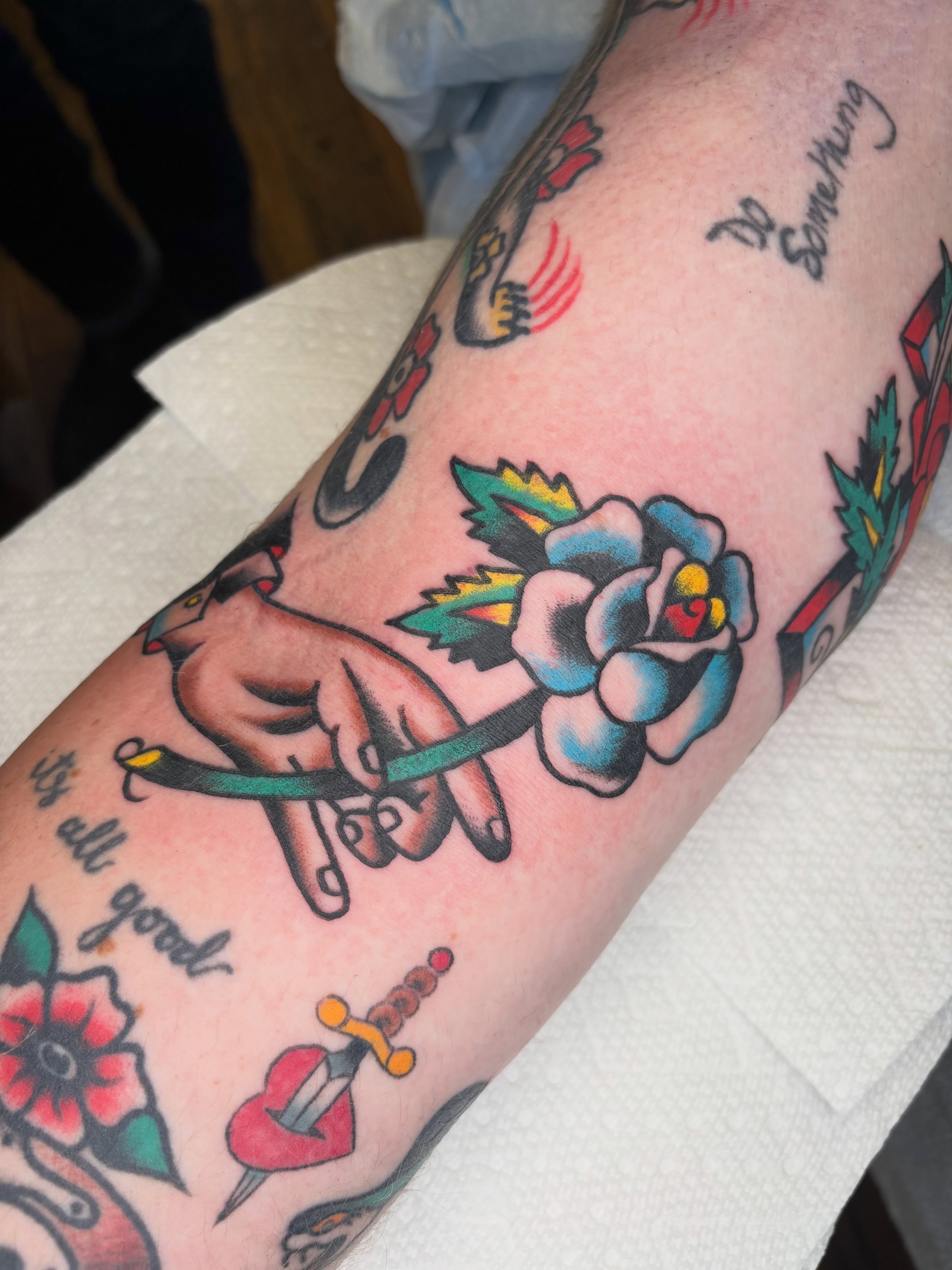 Rose and hand American traditional tattoo on the forearm by Cooper Reichwein