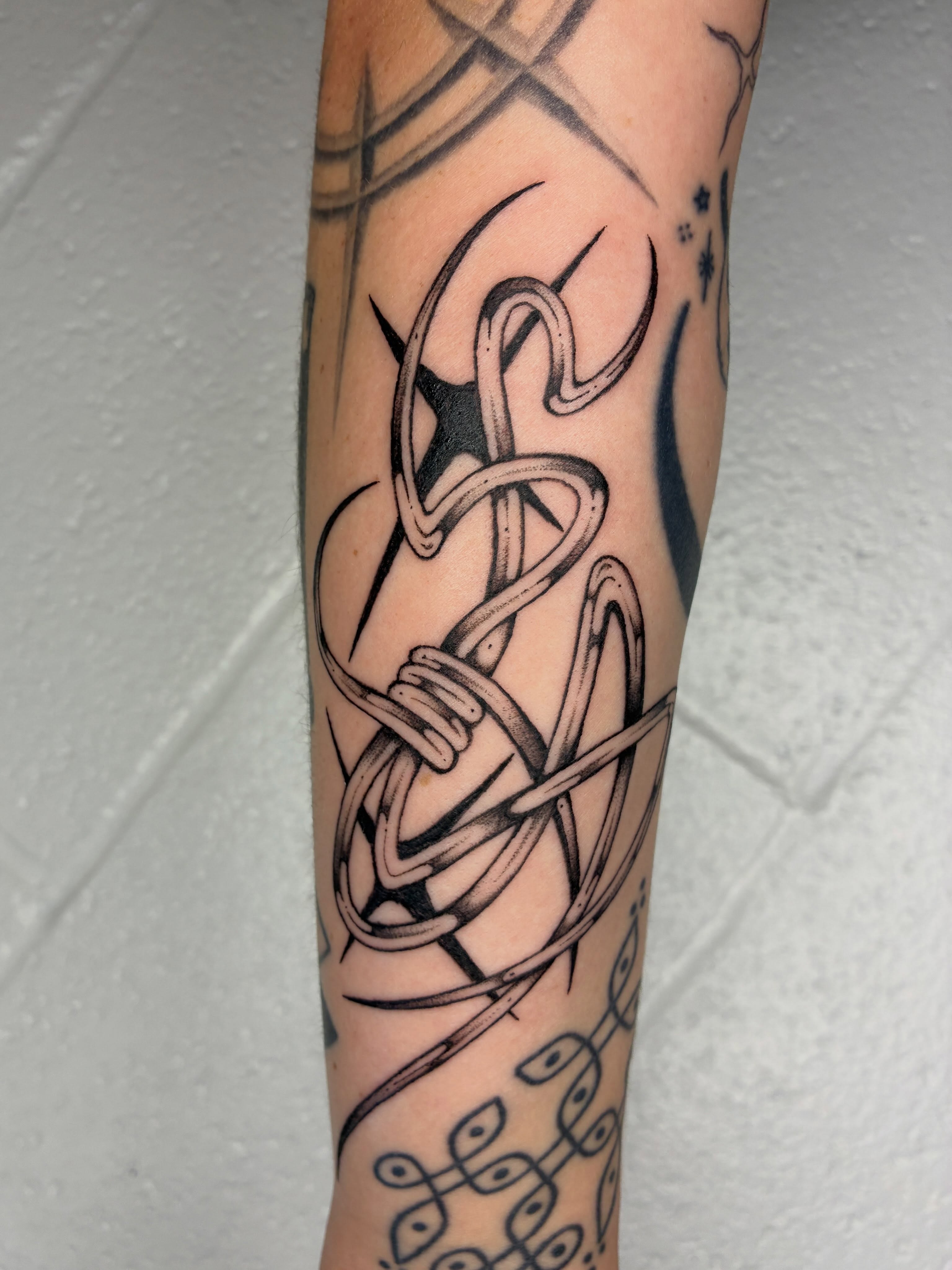String black and grey tattoo on the forearm by Steven Sessler, San Francisco, California