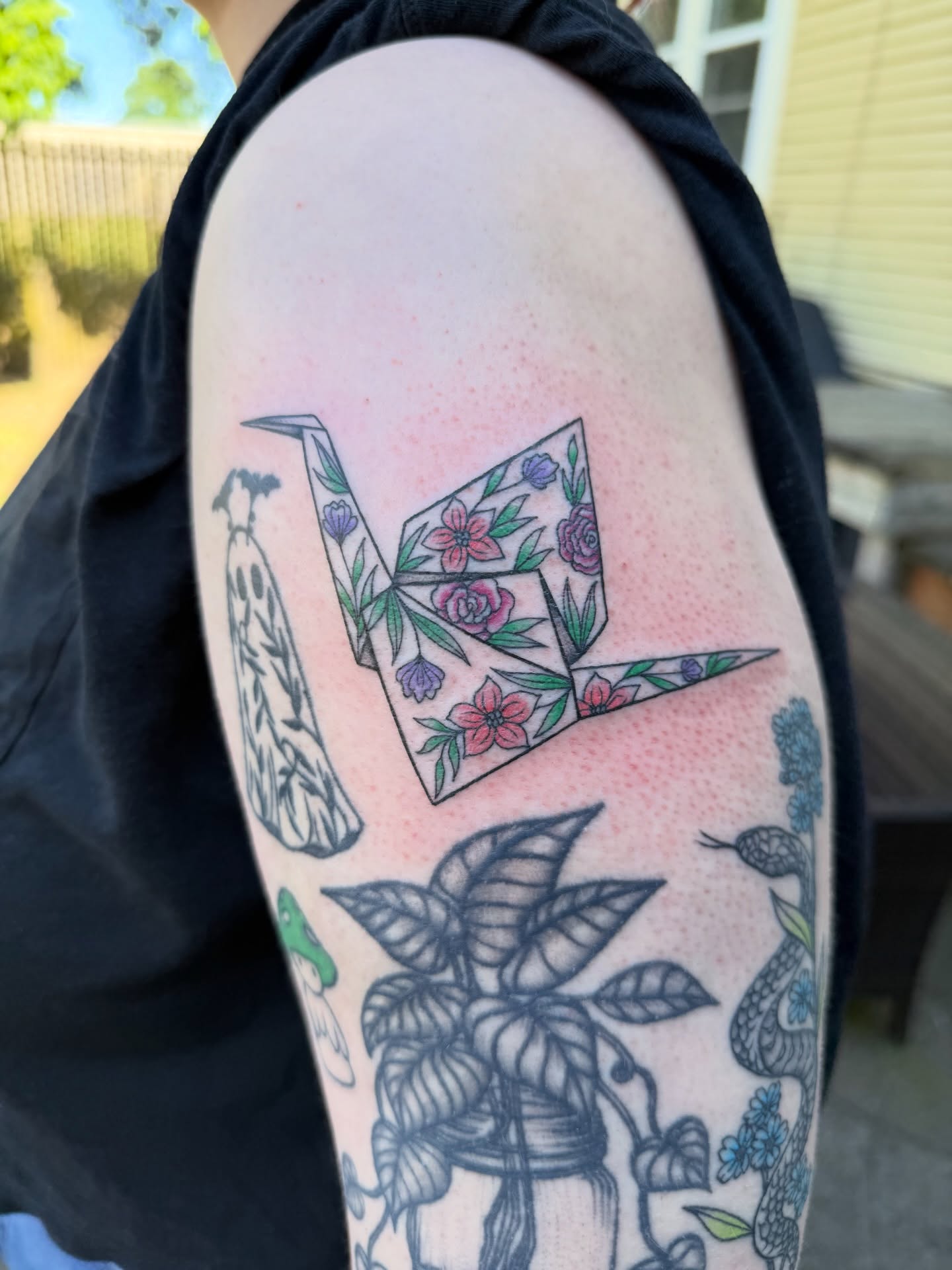 Origami crane geometric tattoo on the upper arm by Jenna Nicole
