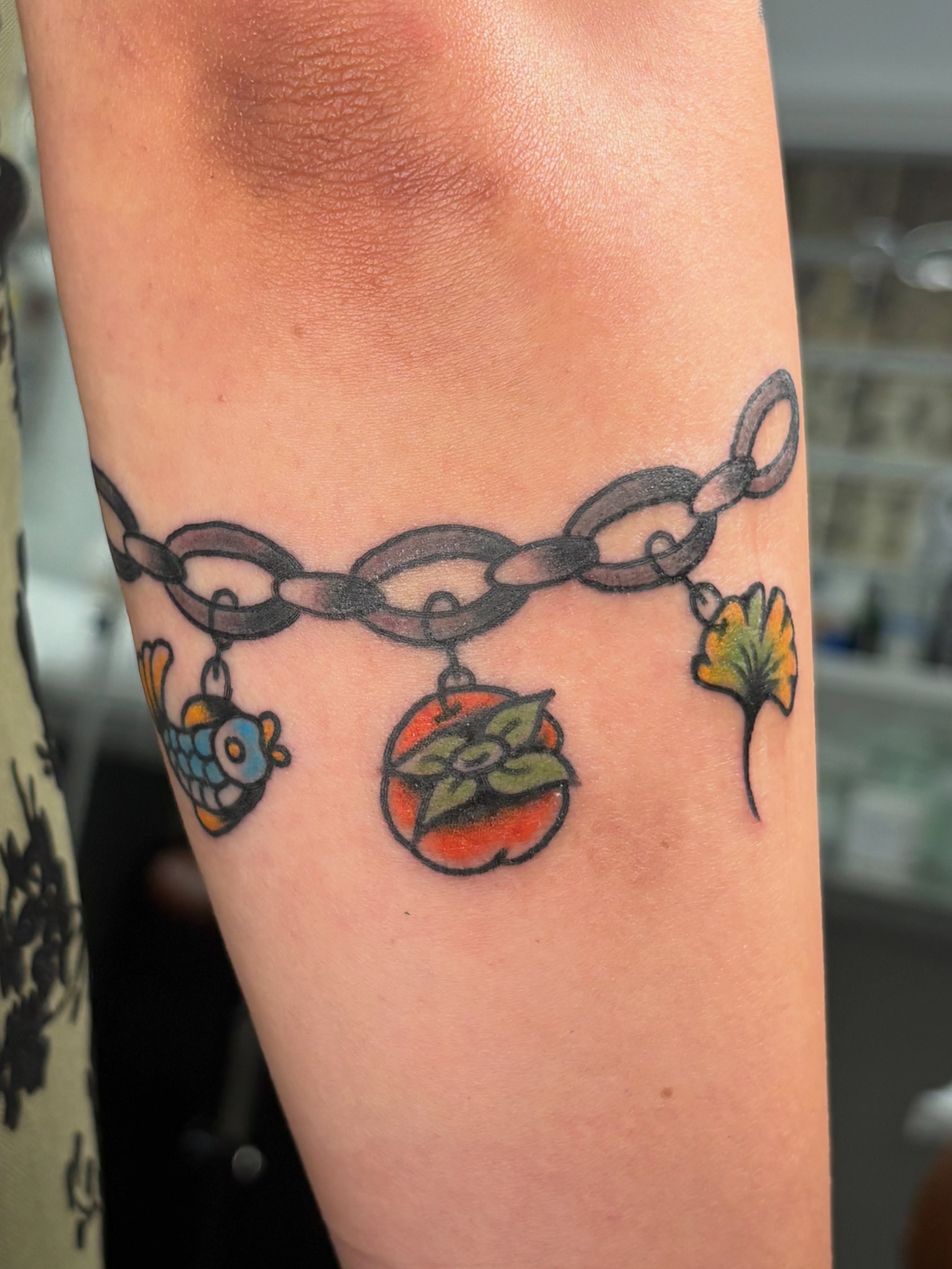 Chain with charms American traditional tattoo on the forearm by Aysia Mankin-Wong, San Francisco, California