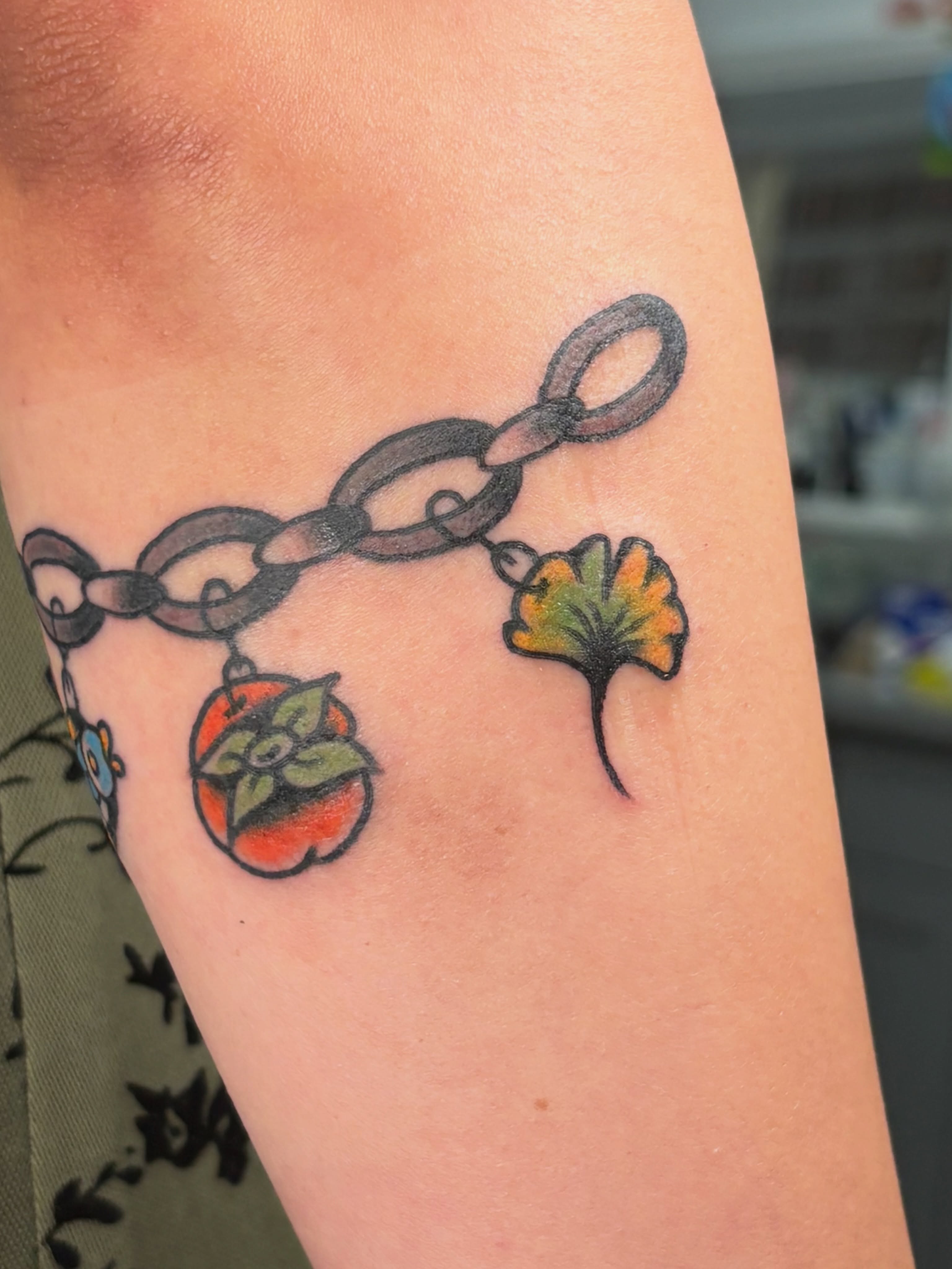 Chain with charms black and grey tattoo on the forearm by Aysia Mankin-Wong, San Francisco, California