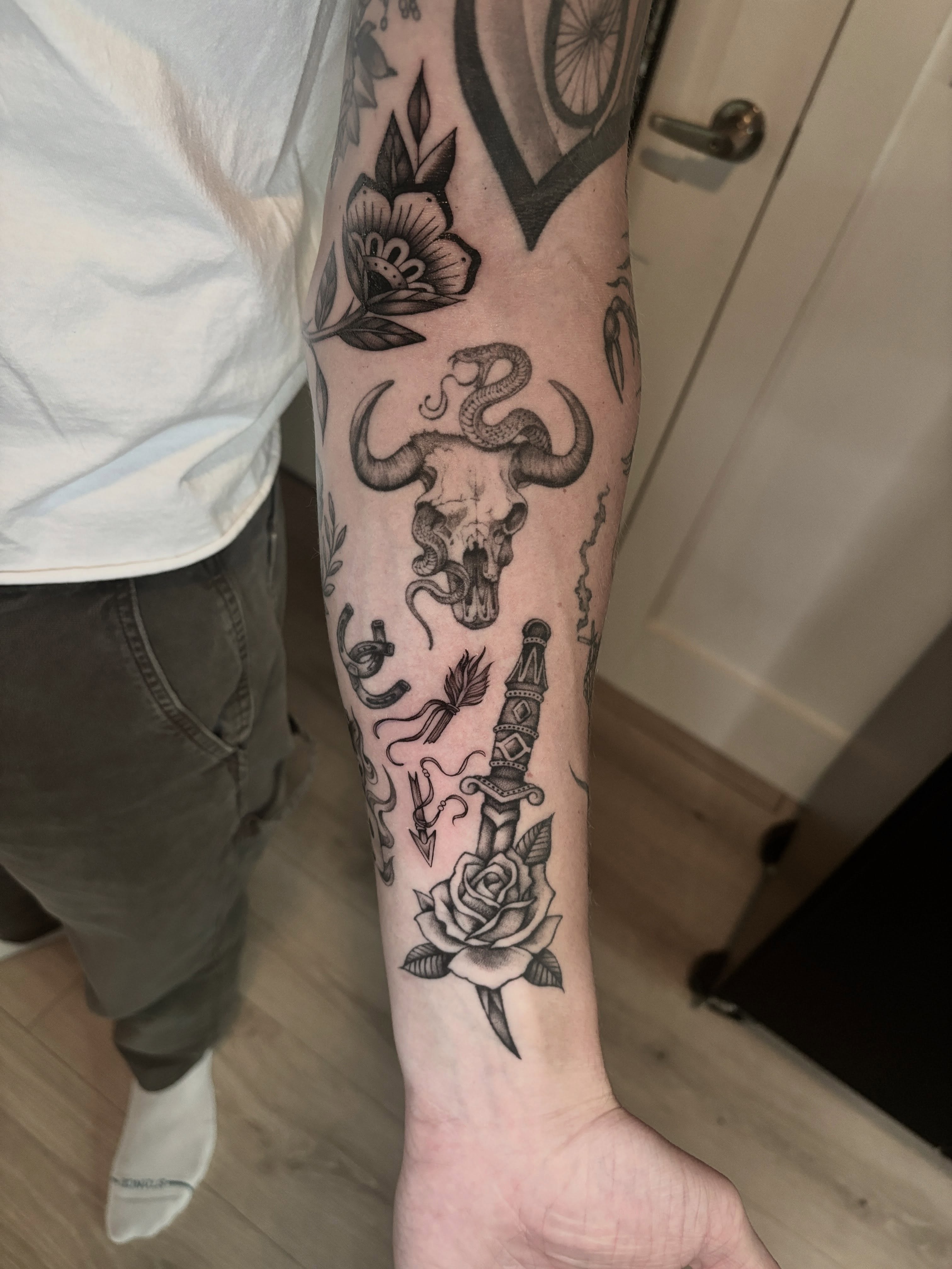 Bull skull with snake black and grey tattoo on the forearm by Emma Cotter