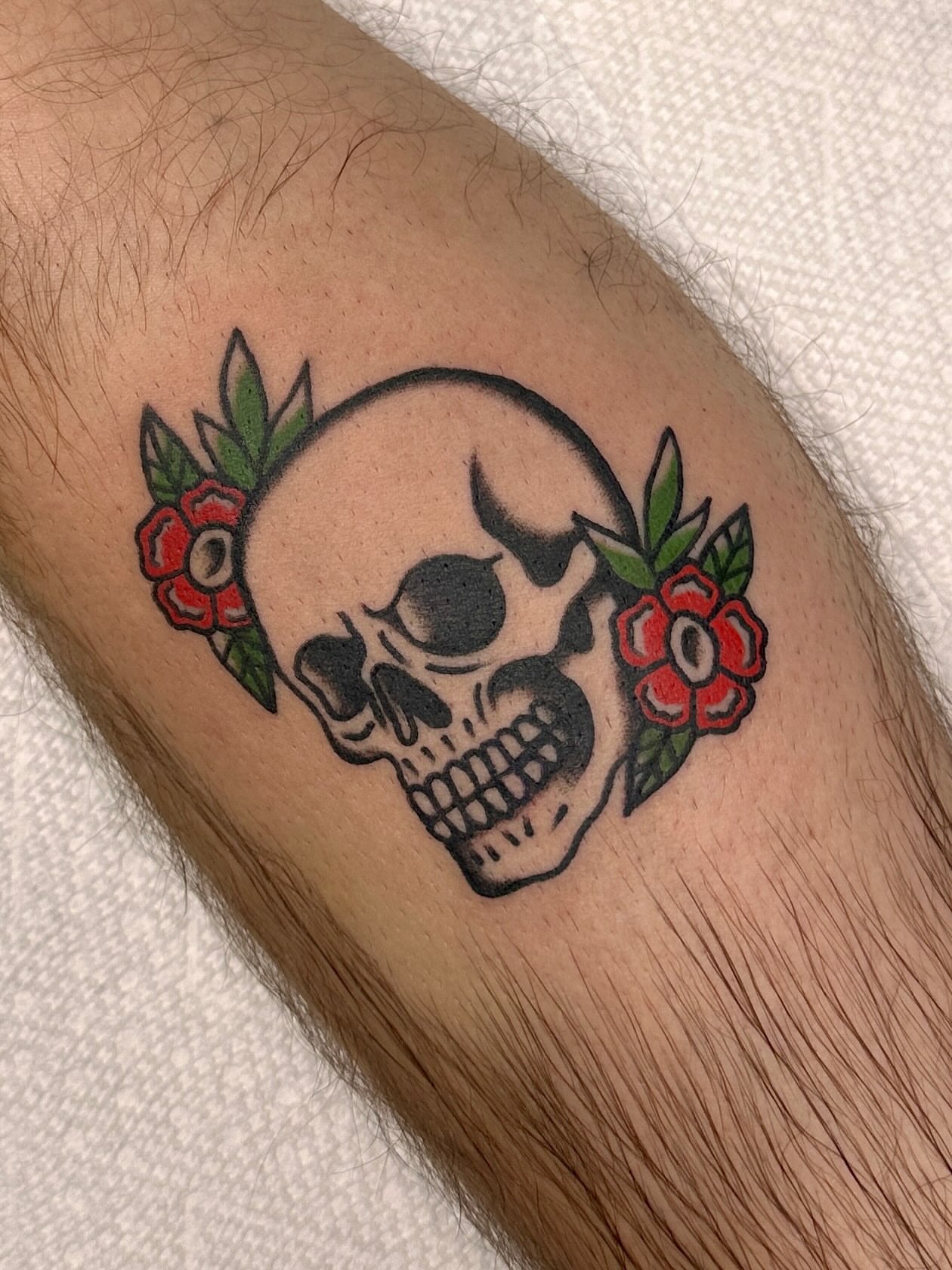 Skull with flowers American traditional tattoo on the forearm by Danelle ✶ Nashville Tattooer