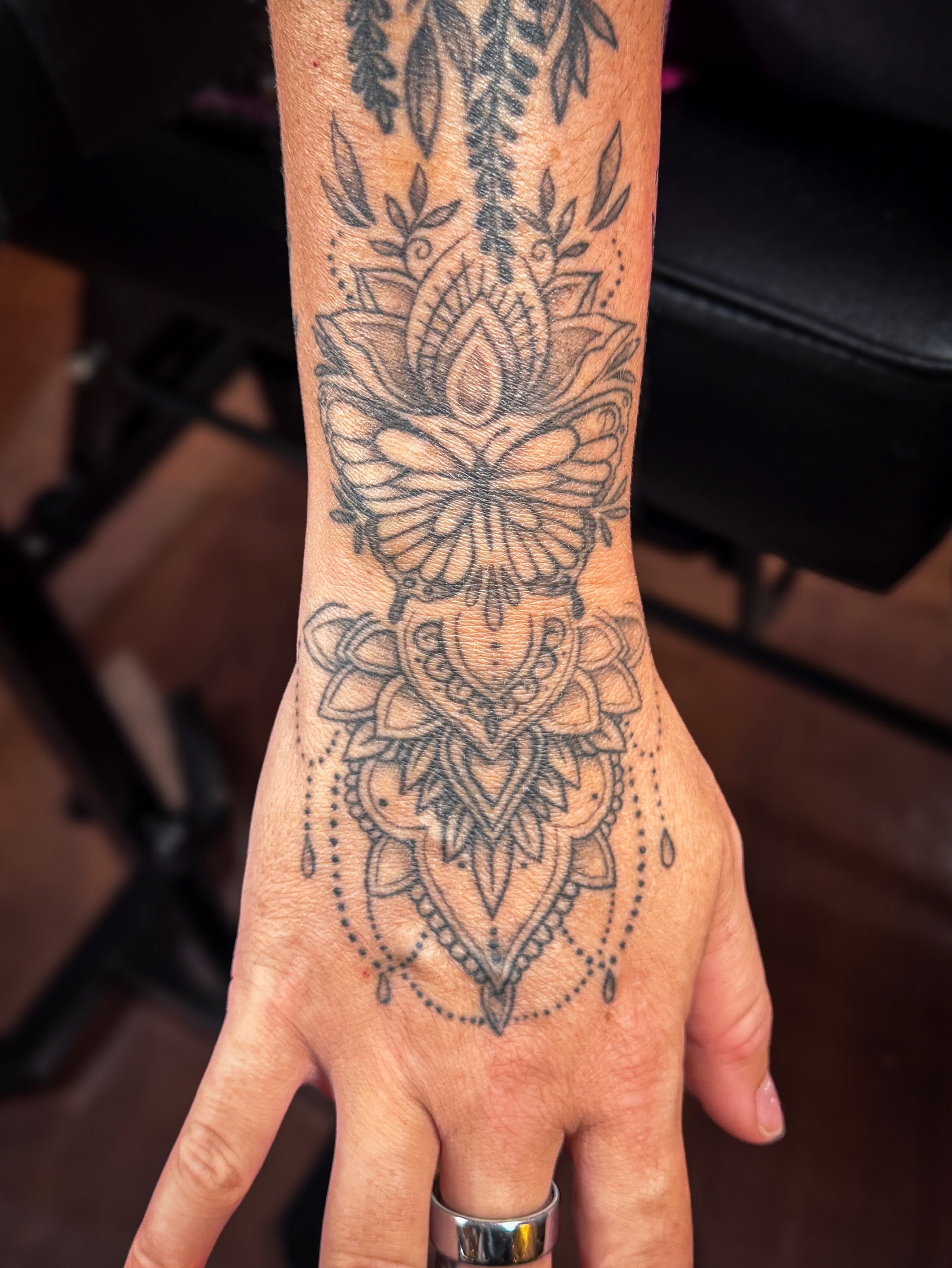 Butterfly and floral mandala dotwork tattoo on the hand by Ash✨