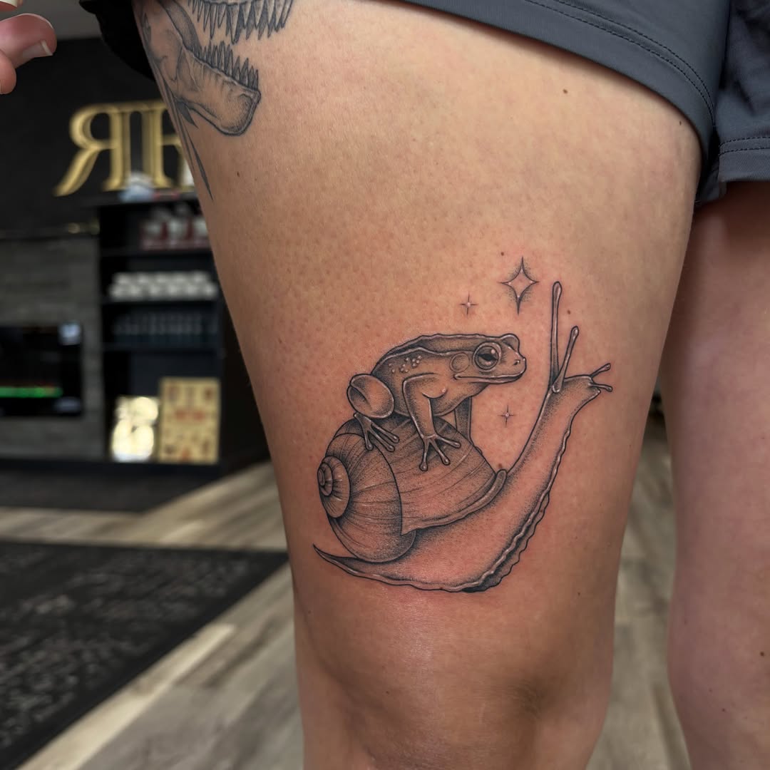 Frog on snail realism tattoo on the thigh by Hailey Nicole
