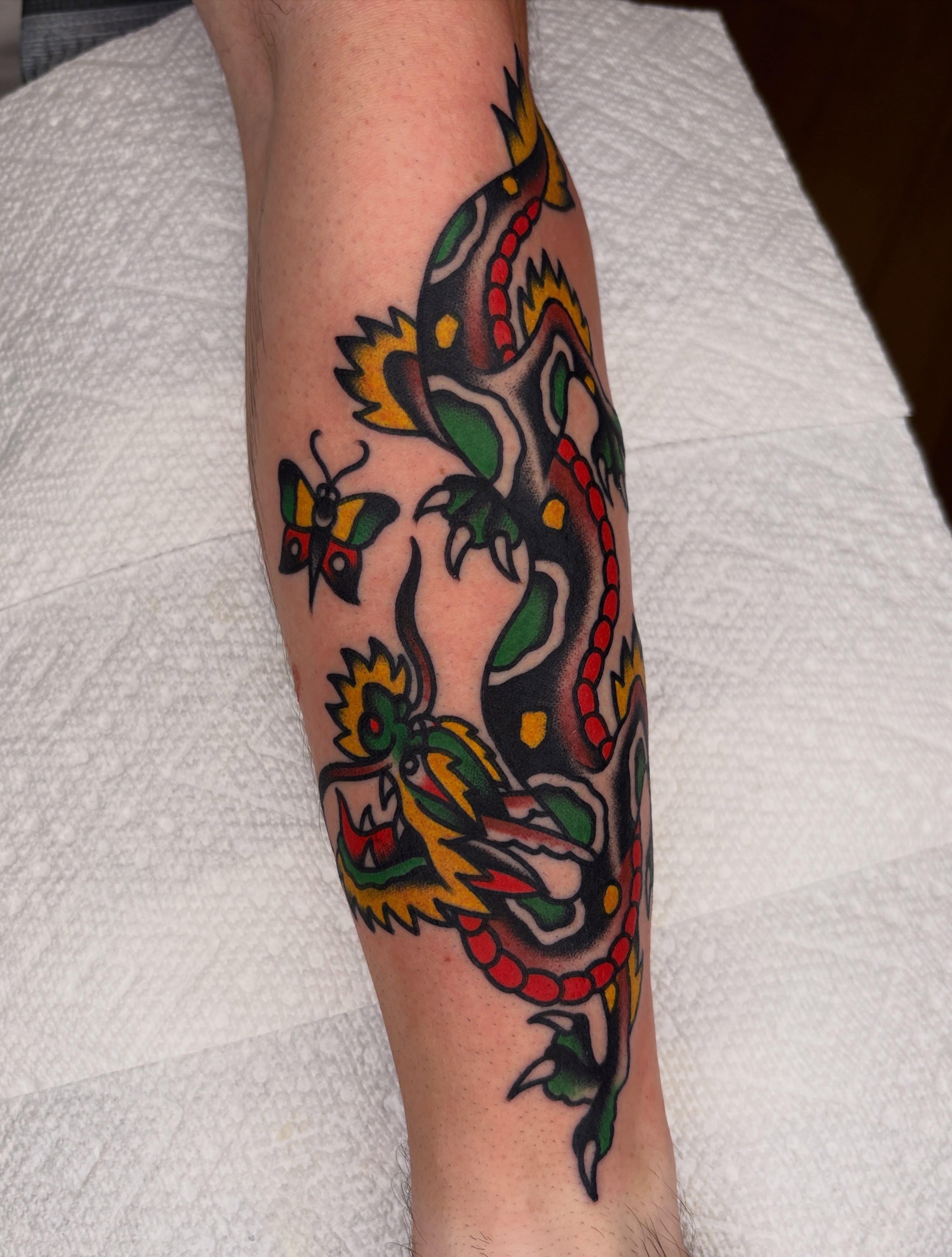 Dragon and butterfly American traditional tattoo on the forearm by John Lemon