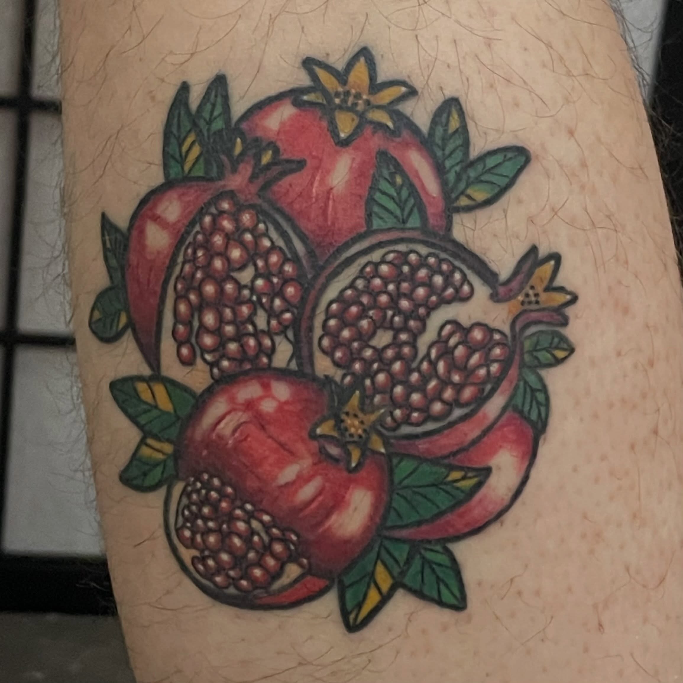 Pomegranate American traditional tattoo on the forearm by Avalon Sable