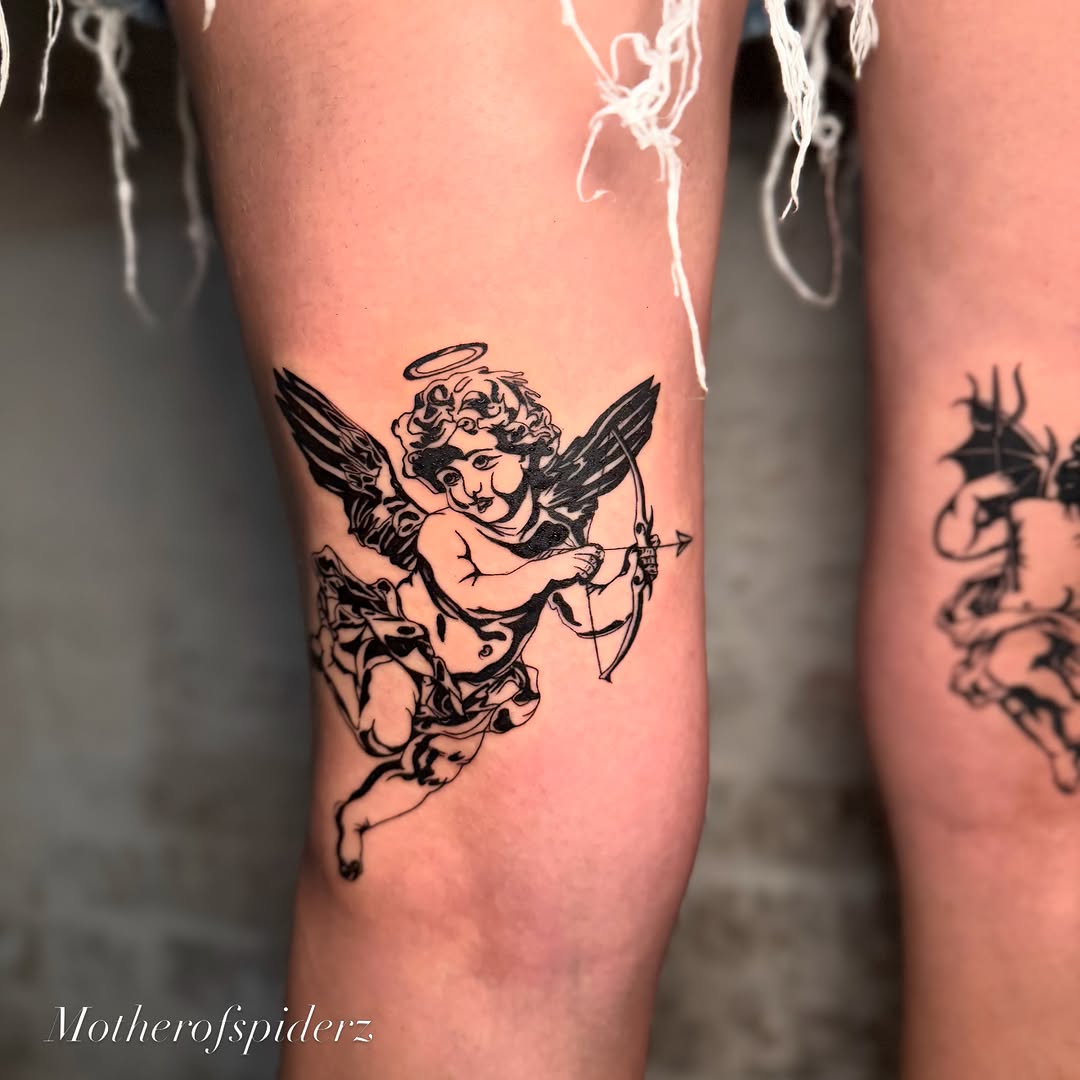 Cherub with bow black and grey tattoo on the thigh by Alyssa Garza