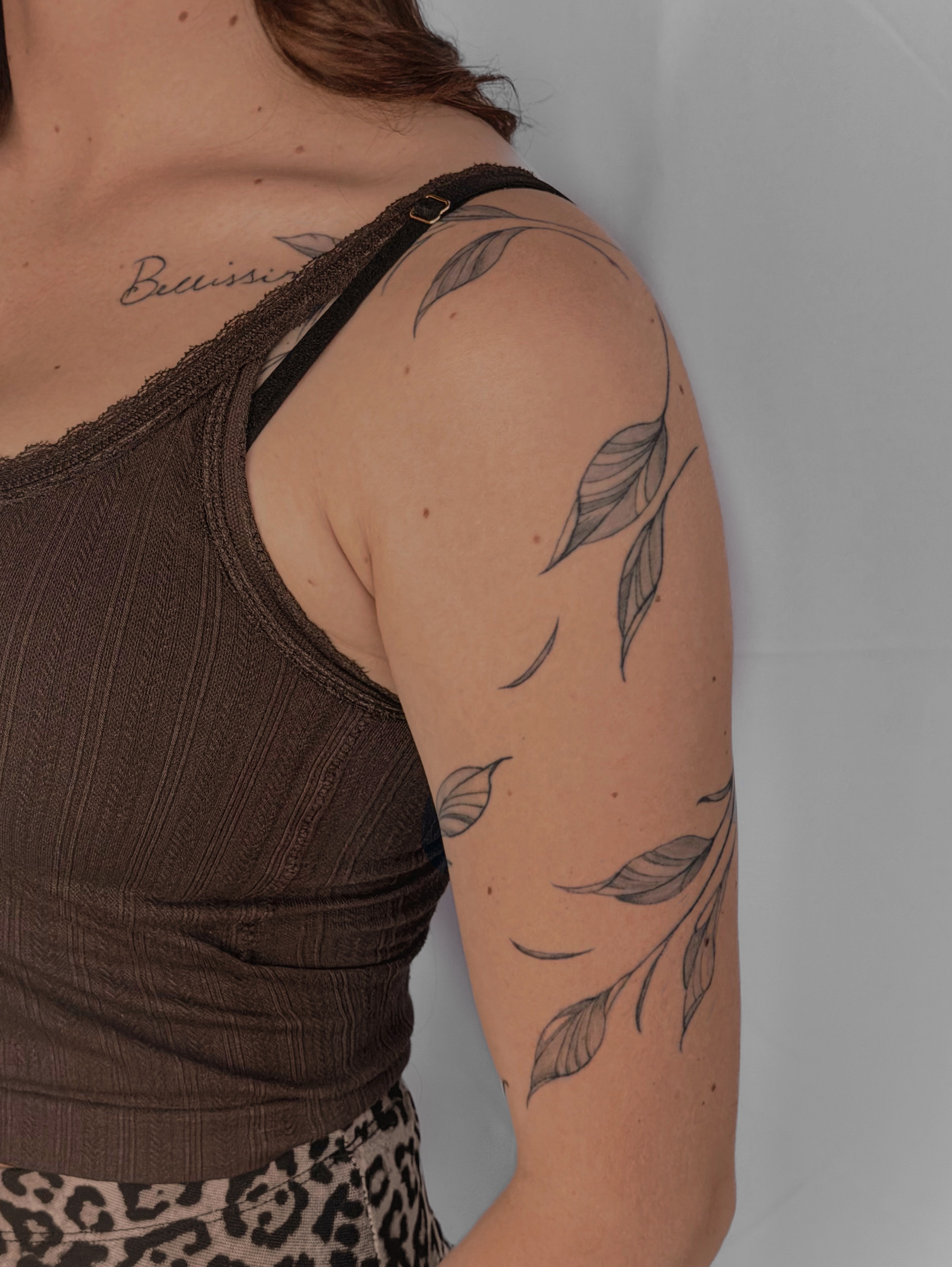 Leaf black and grey tattoo on the upper arm by Charlotte