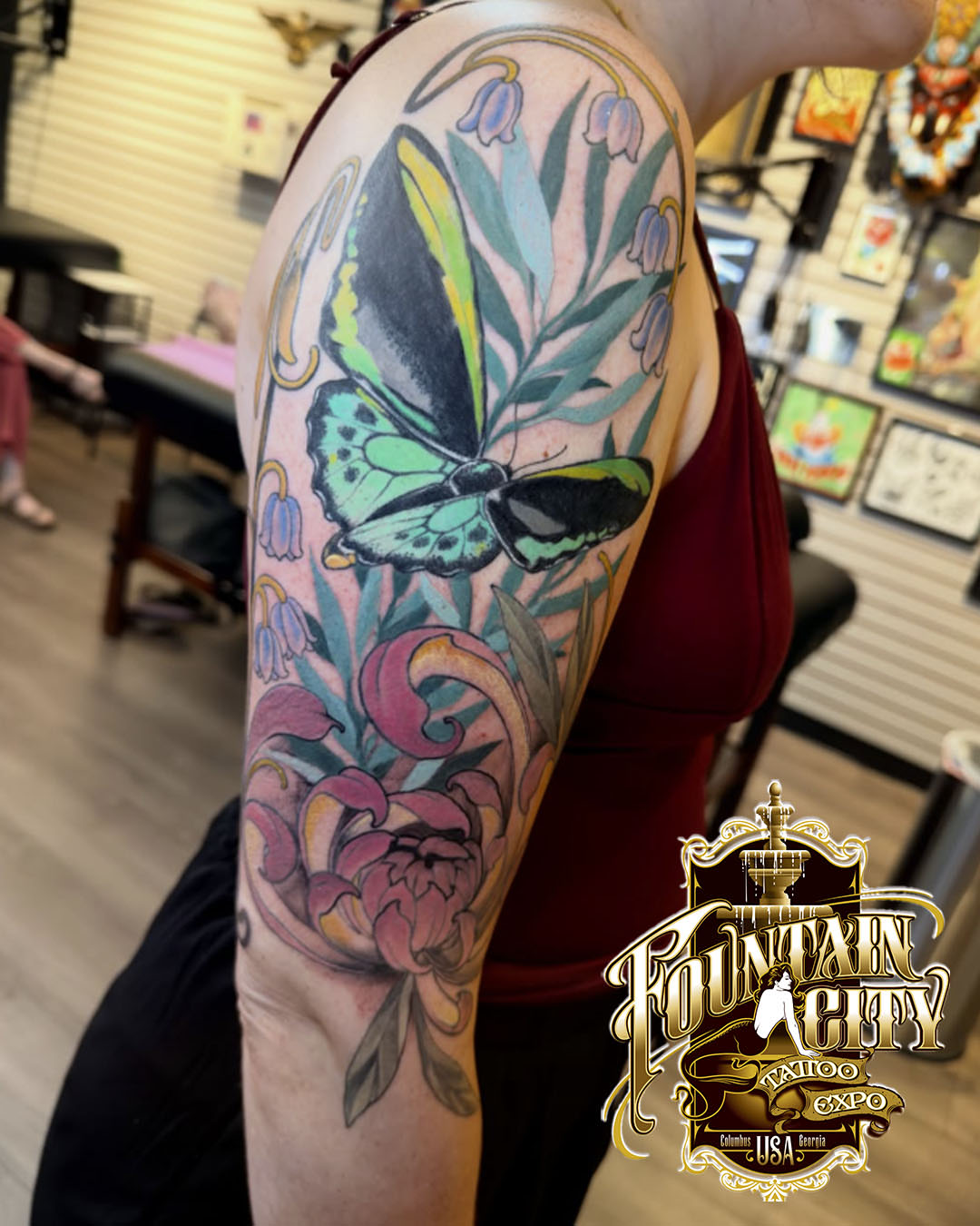 Butterfly and floral new school tattoo on the upper arm by Jenn Golgan
