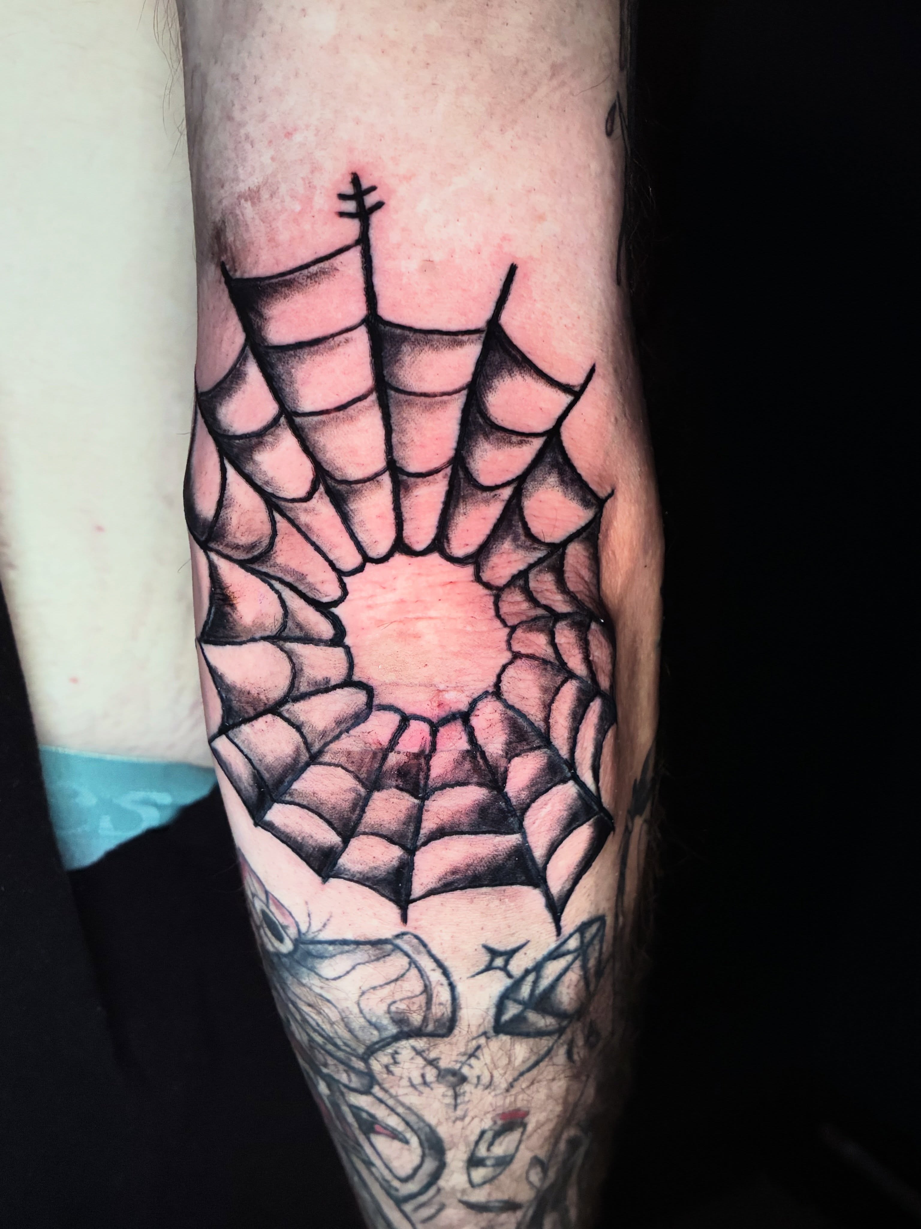 Spiderweb geometric tattoo on the forearm by Evan Intveld