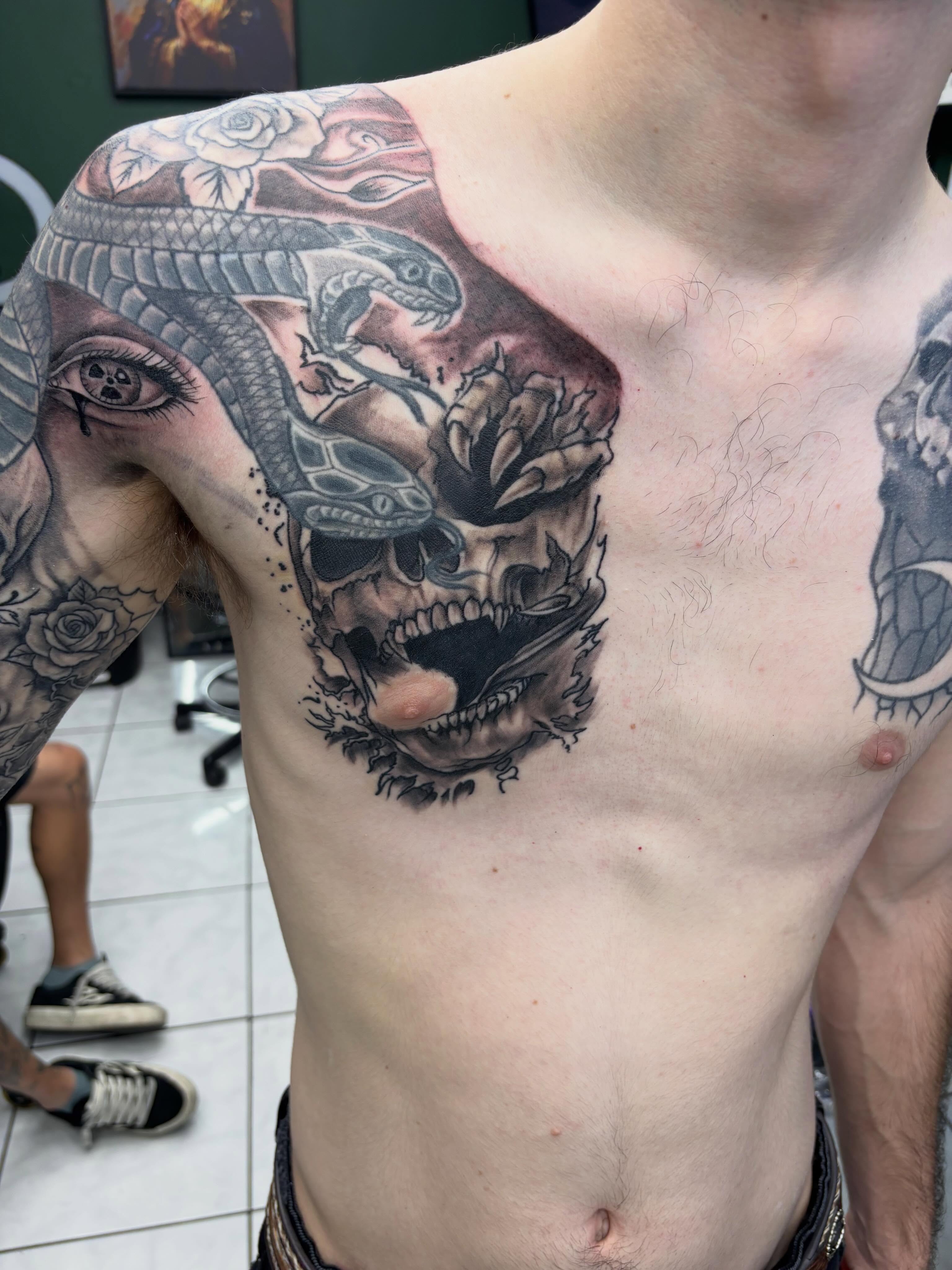 Skull with snakes realism tattoo on the chest by Shadows Tattoos