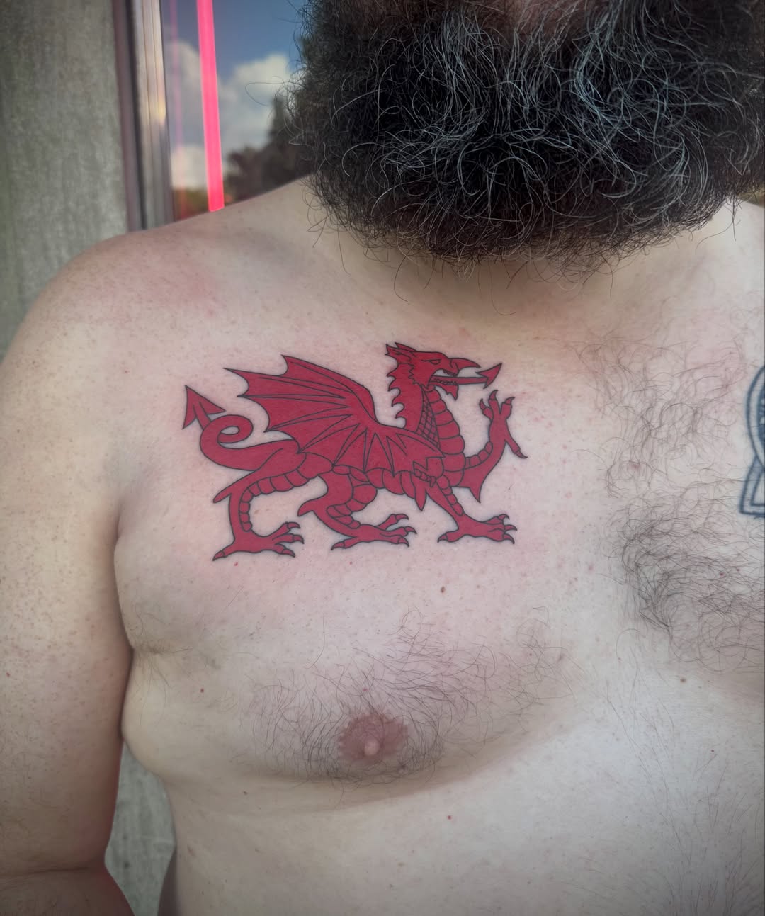 Wales dragon American traditional tattoo on the chest by Kylie Allen