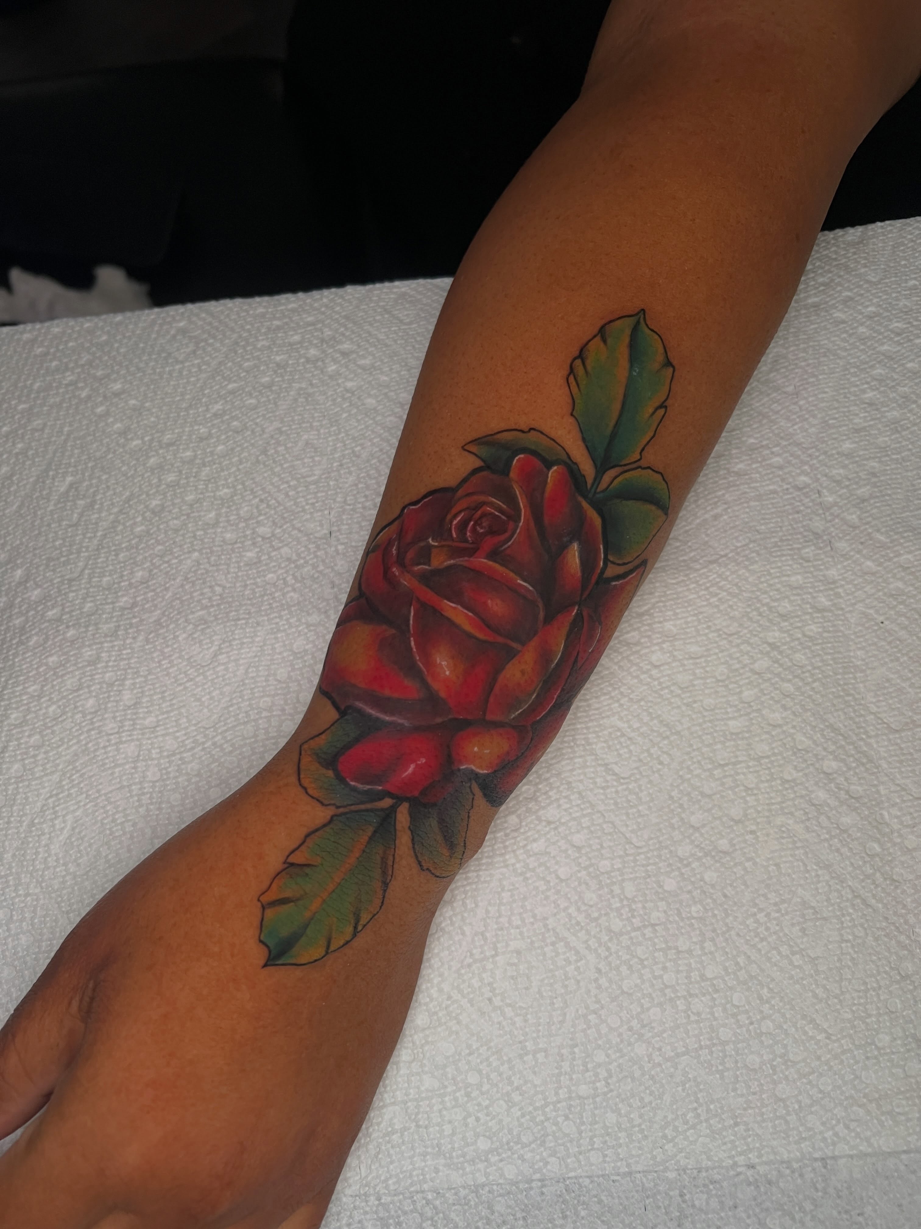Red rose American traditional tattoo on the forearm by Justx4rt