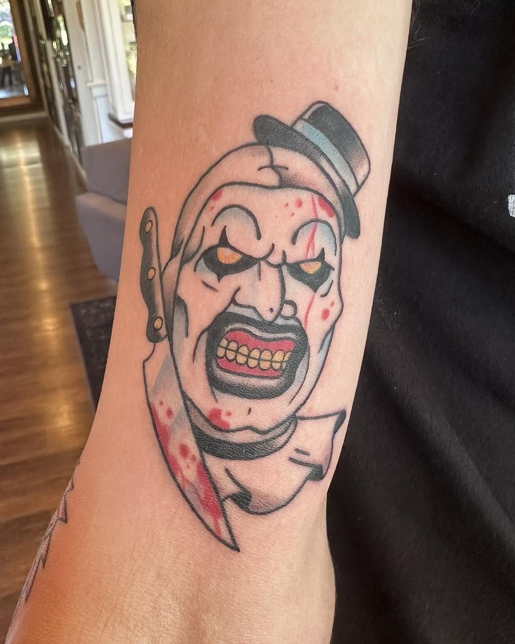 Clown dark realism tattoo on the forearm by Robert Morrow