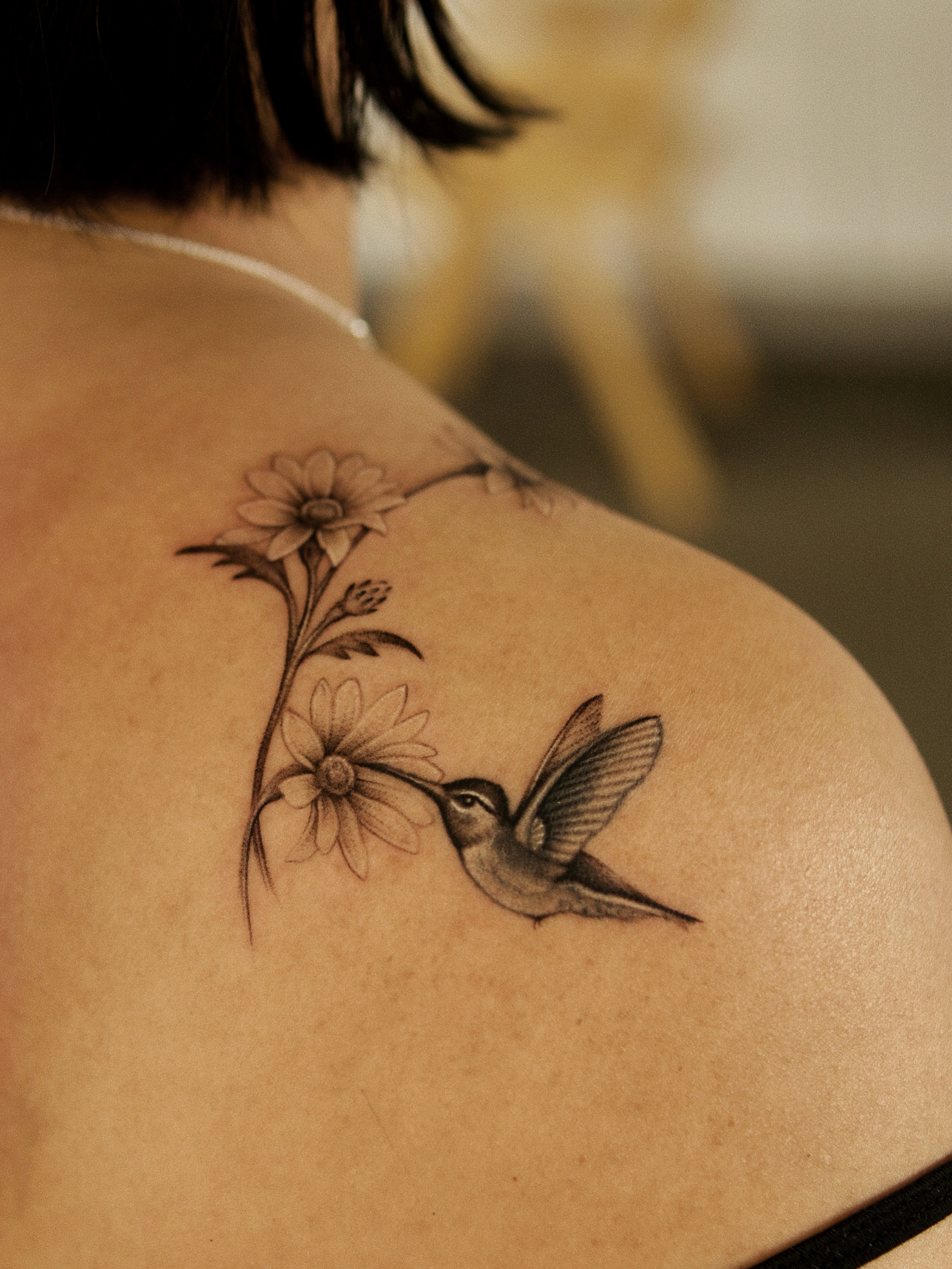 Hummingbird and flowers realism tattoo on the shoulder by Ray Quinday