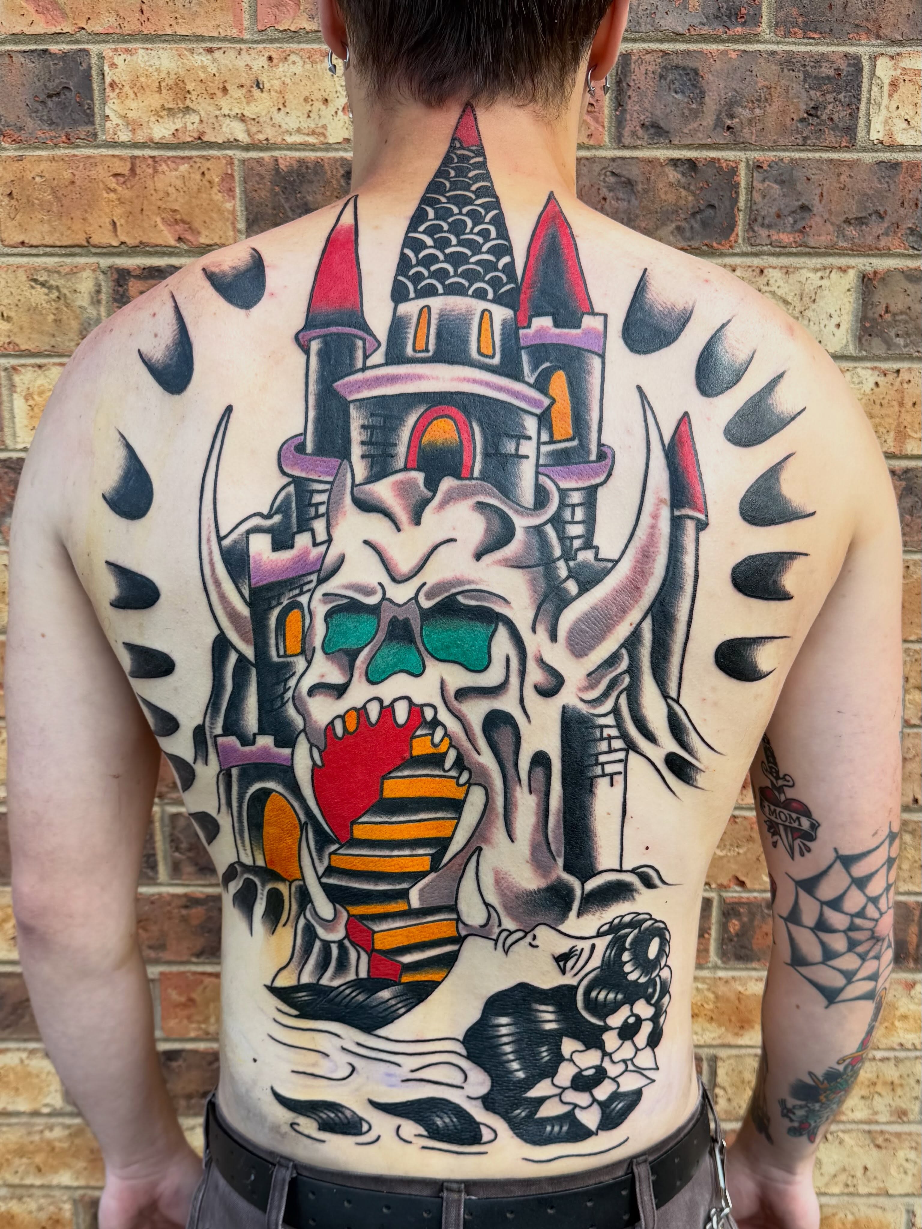 Castle skull American traditional tattoo on the back by Don Lee