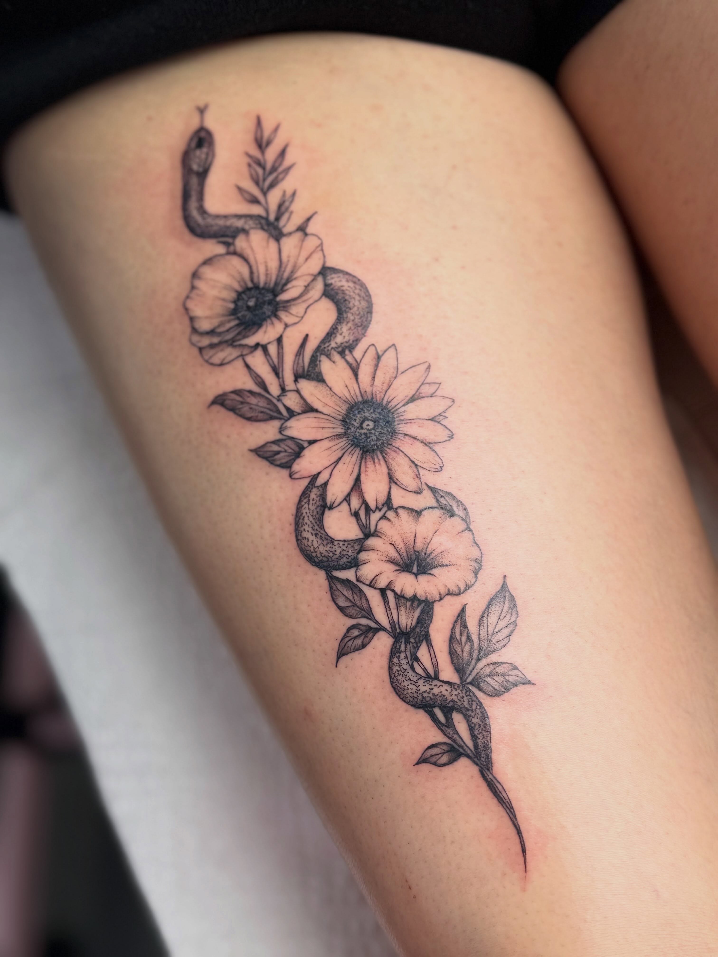 Snake and flowers black and grey tattoo on the thigh by Tetiana