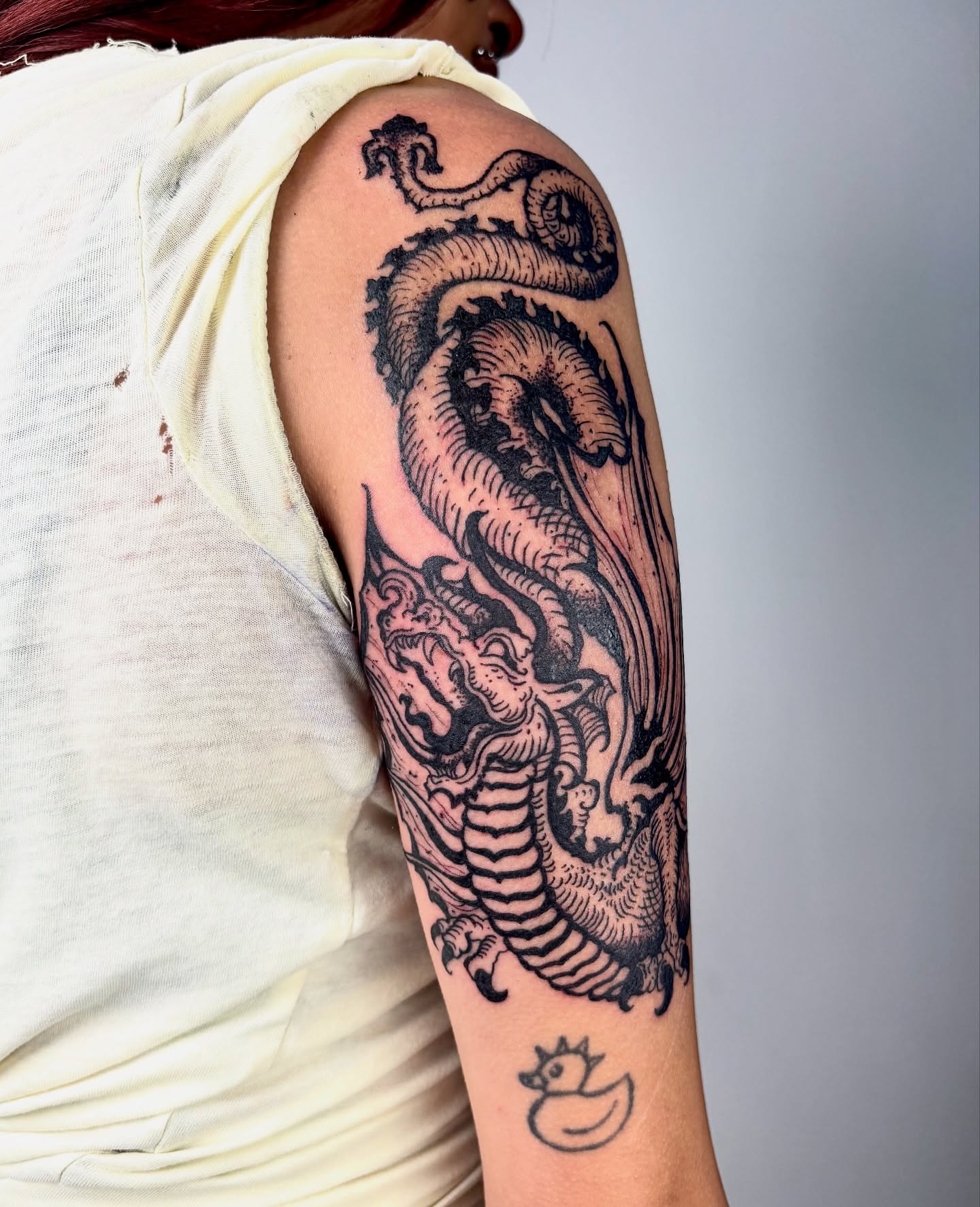 Dragon black and grey tattoo on the upper arm by kendle