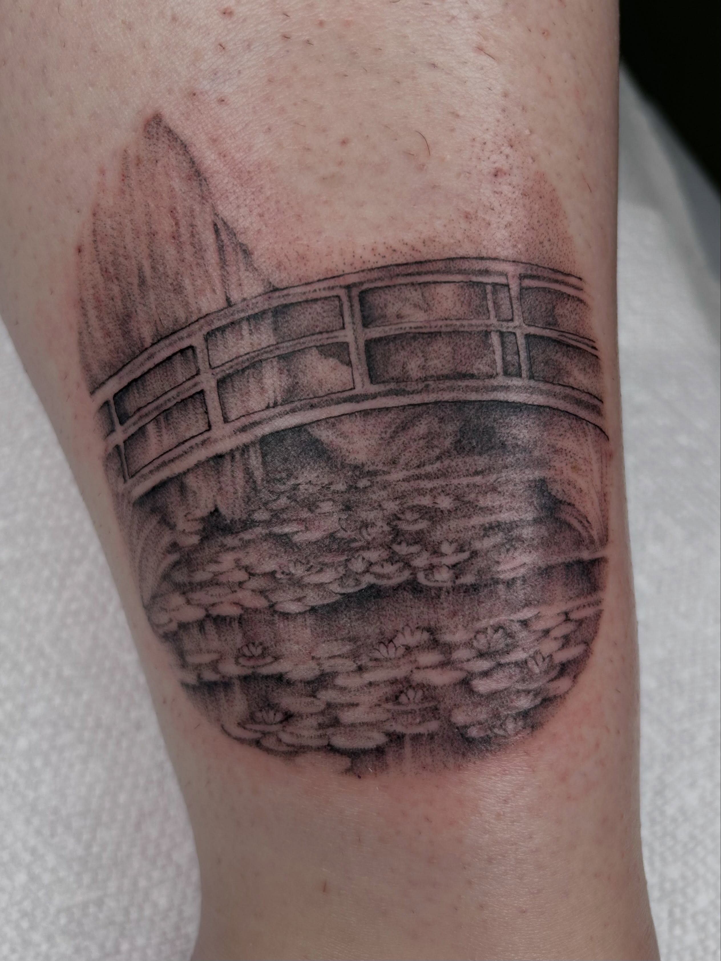 Bridge over water realism tattoo on the forearm by Olivia Fox