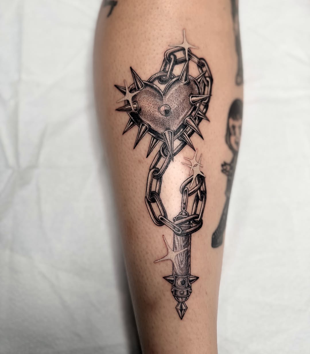 Heart with spikes and chain geometric tattoo on the forearm by Valerie Dominguez
