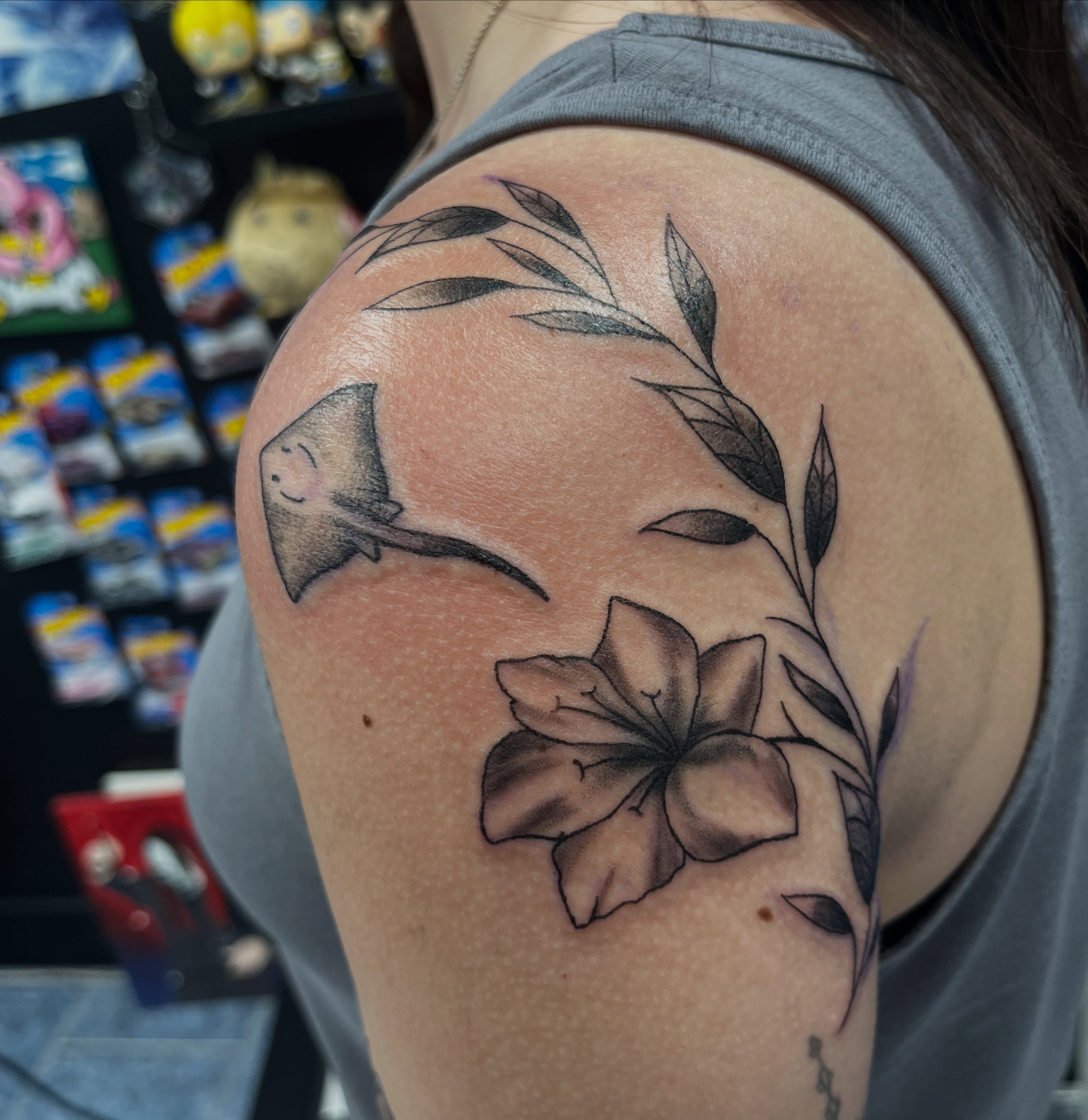 Ray and flower black and grey tattoo on the shoulder by @artinjections667