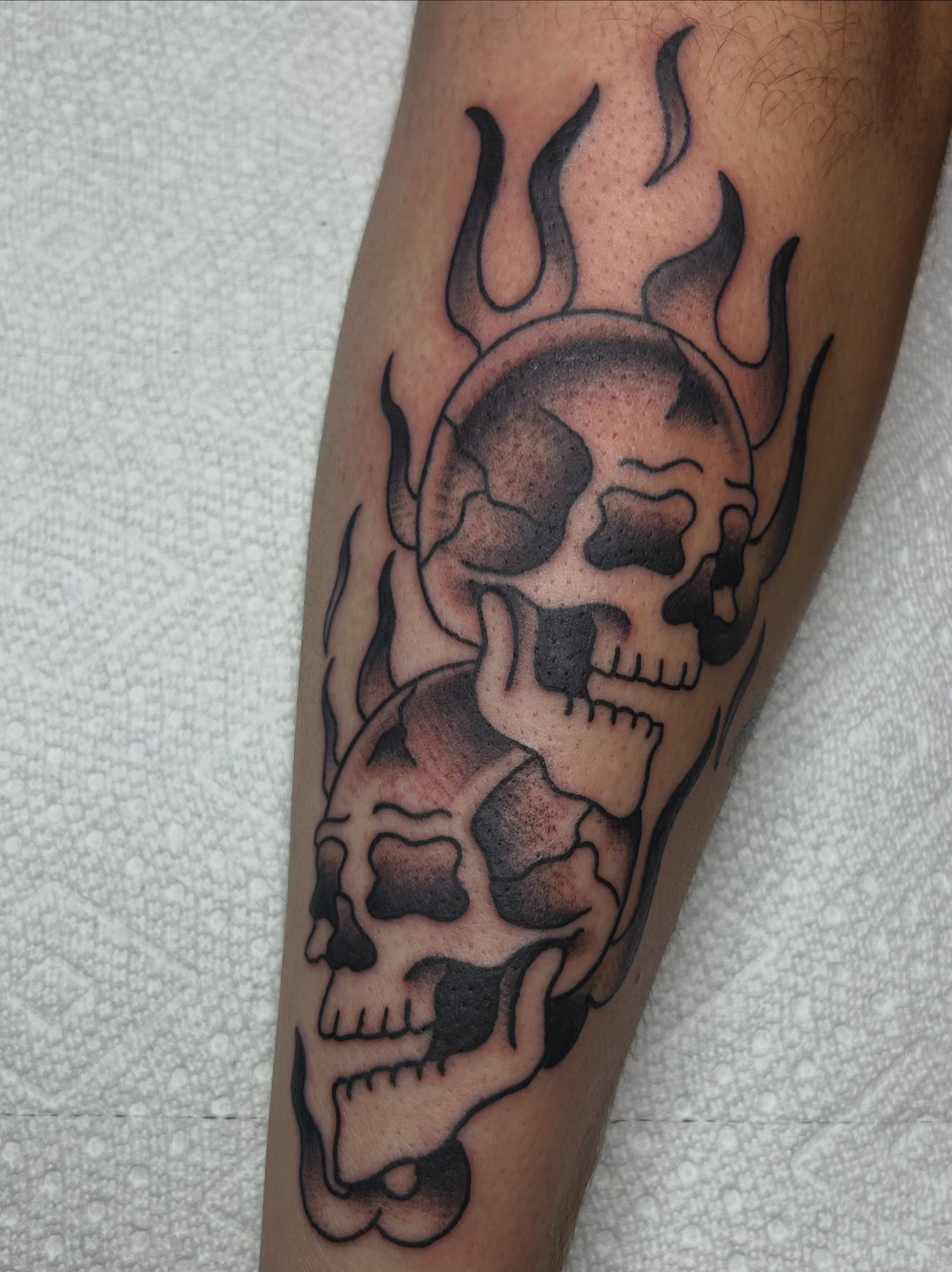 Skulls black and grey tattoo on the forearm by Zach Andrews