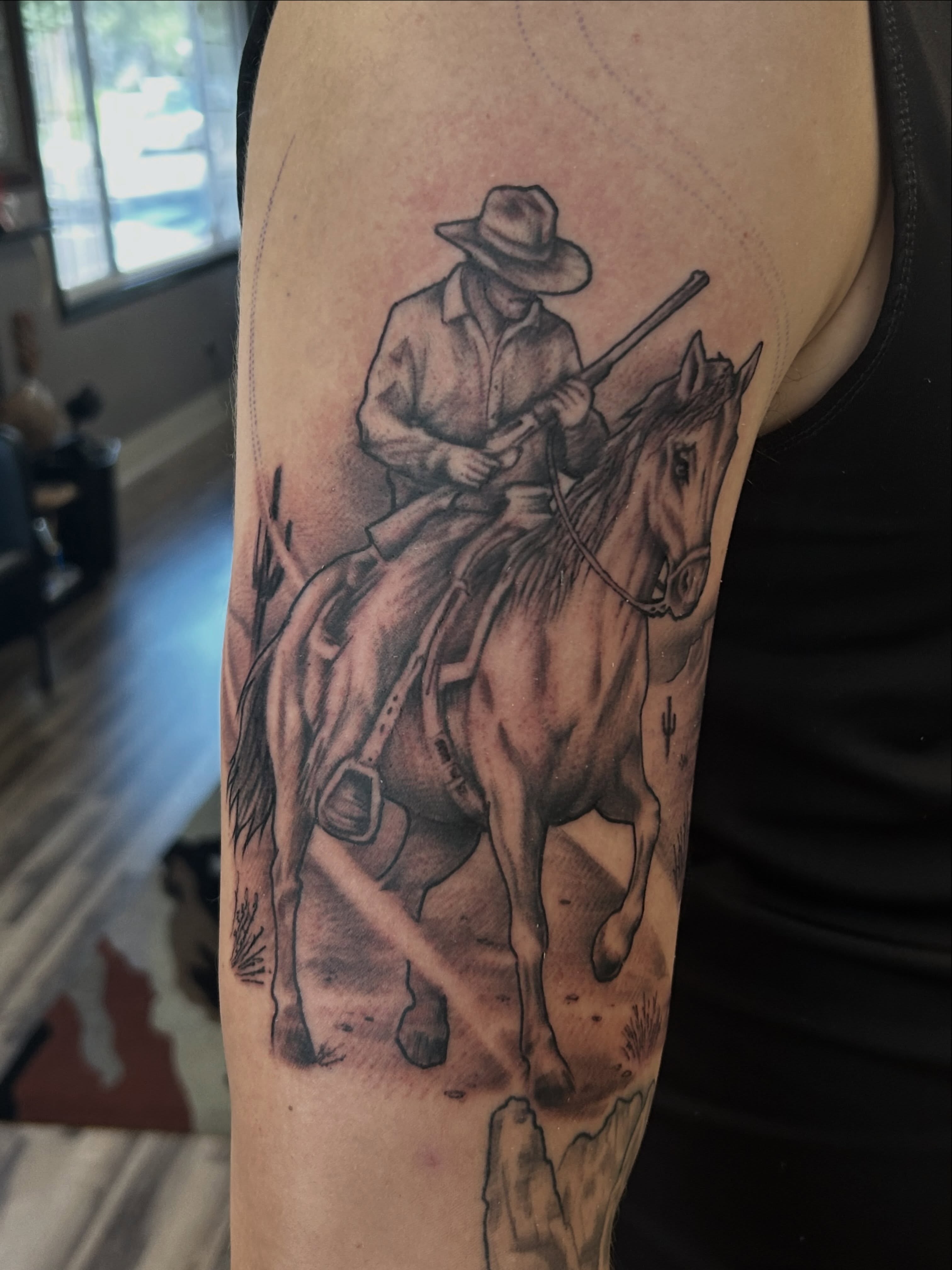 Cowboy on horseback realism tattoo on the forearm by Dan Schuster