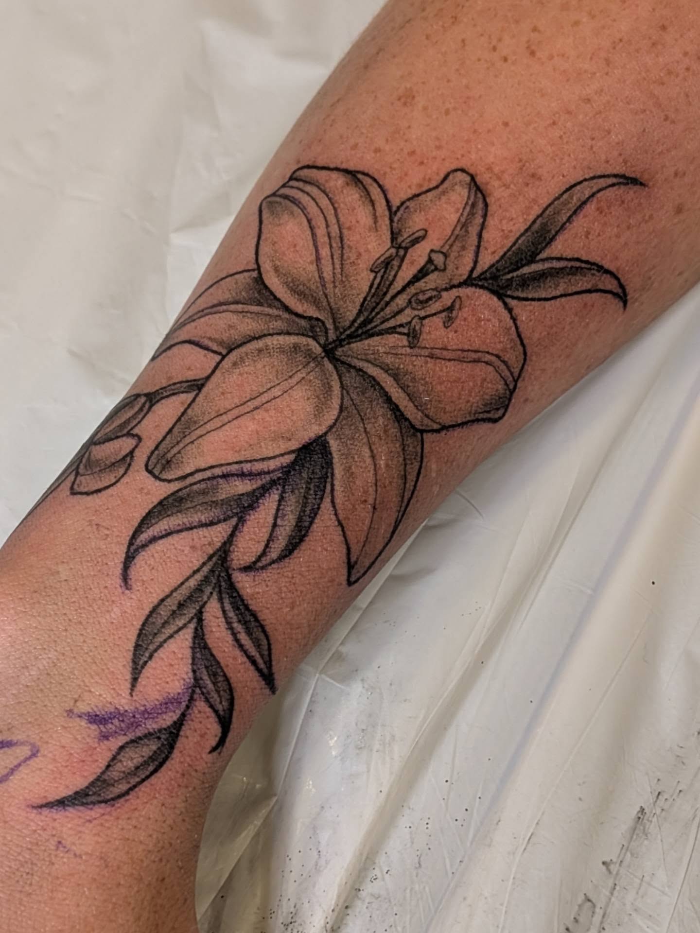 Lily black and grey tattoo on the forearm by Michaela May