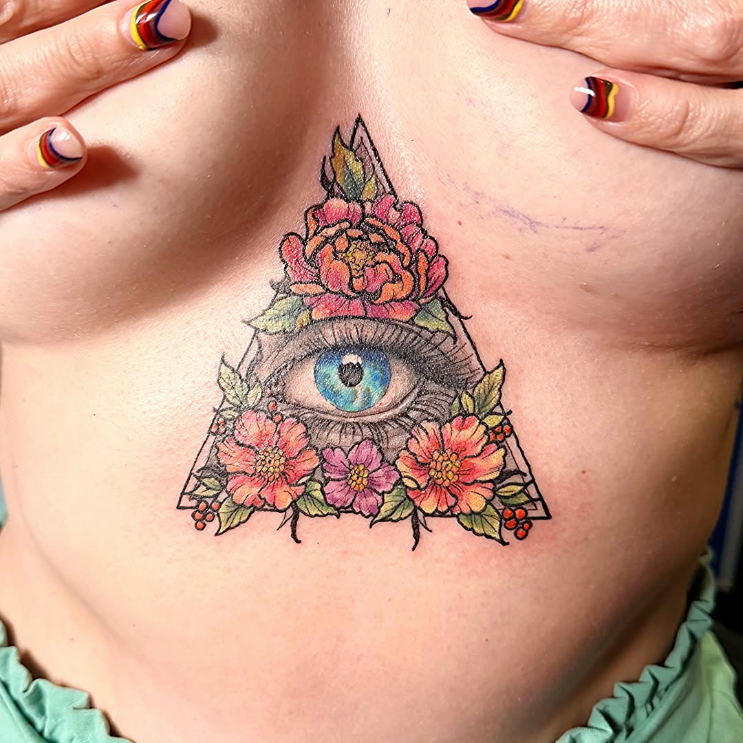 Eye and floral triangle new school tattoo on the chest by Stephanie Comito-Stephens