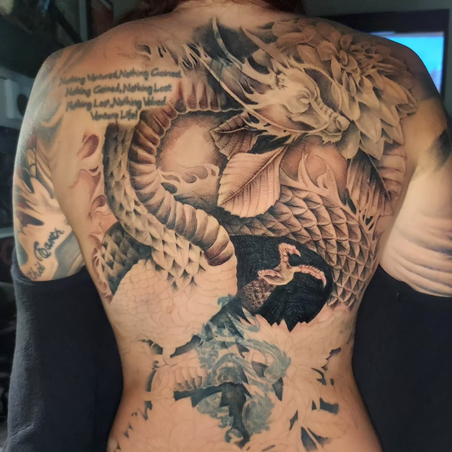 Dragon and leaves realism tattoo on the back by Vex Ink Tattoo