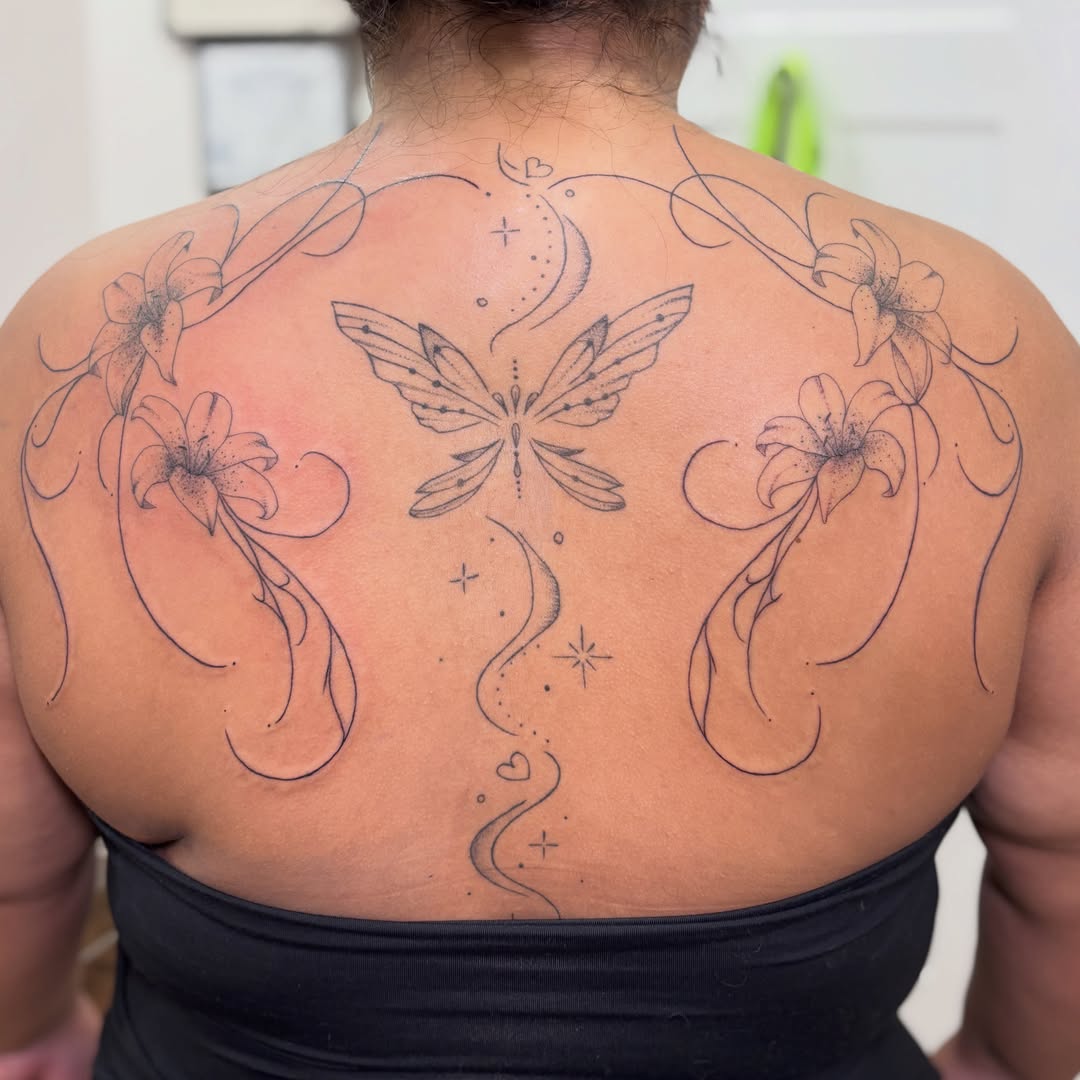 Butterfly and lilies dotwork tattoo on the back by Kendra Parkis
