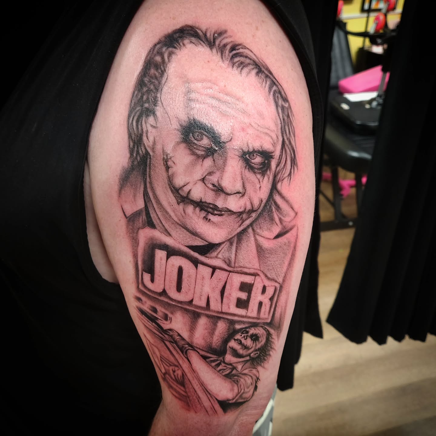 Joker realism tattoo on the upper arm by Eric Richards