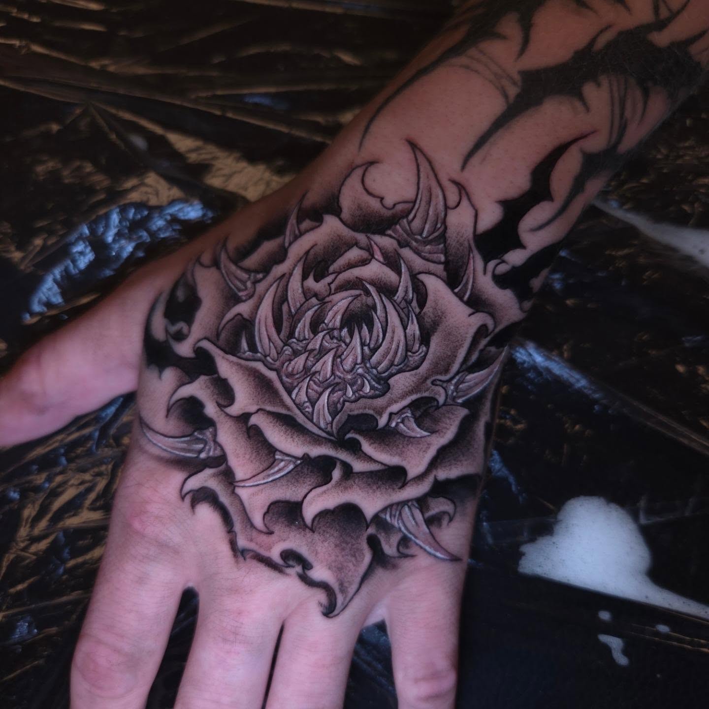 Floral design black and grey tattoo on the hand by Devan Vankirk