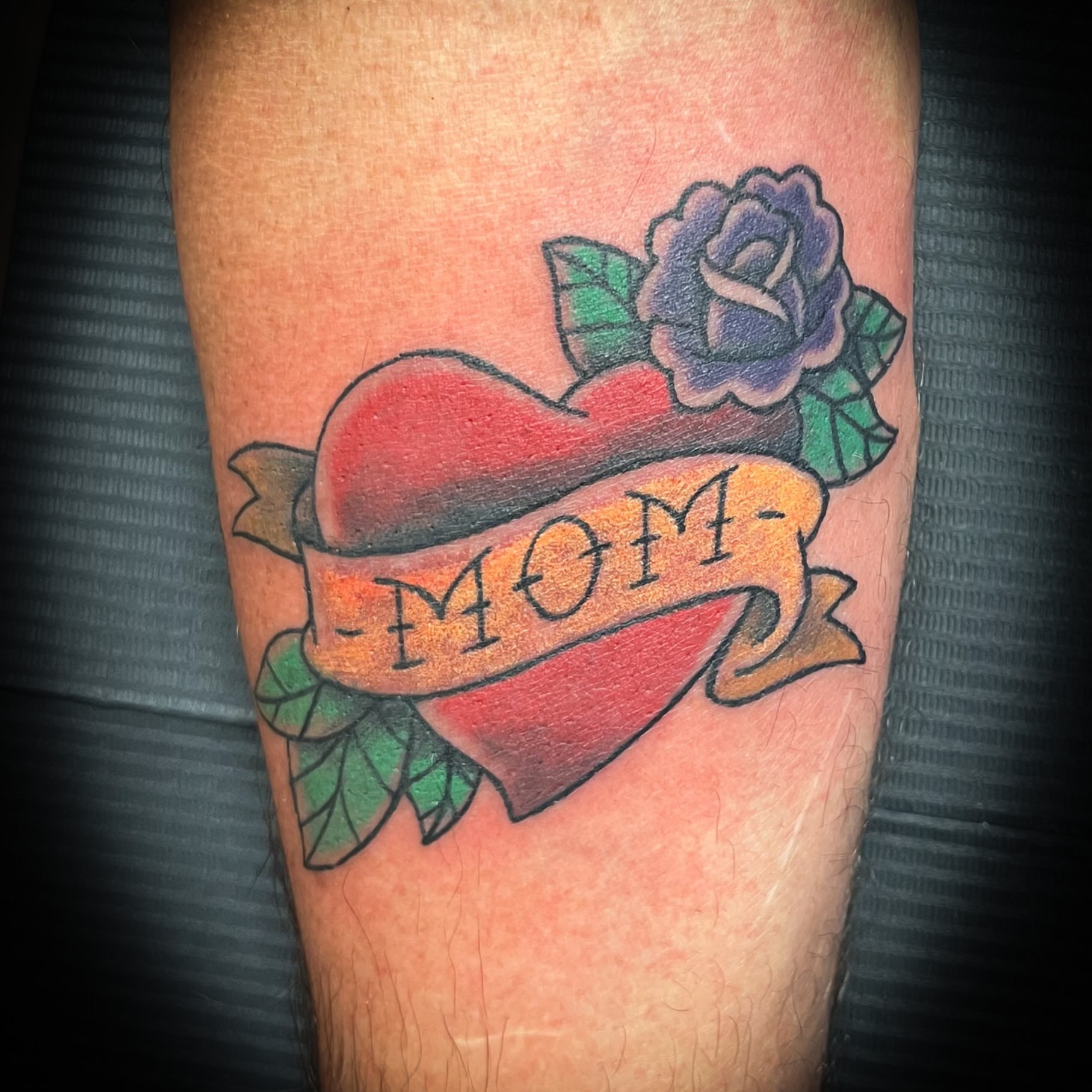 Heart with 'mom' banner American traditional tattoo on the forearm by Melissa Peña NYC