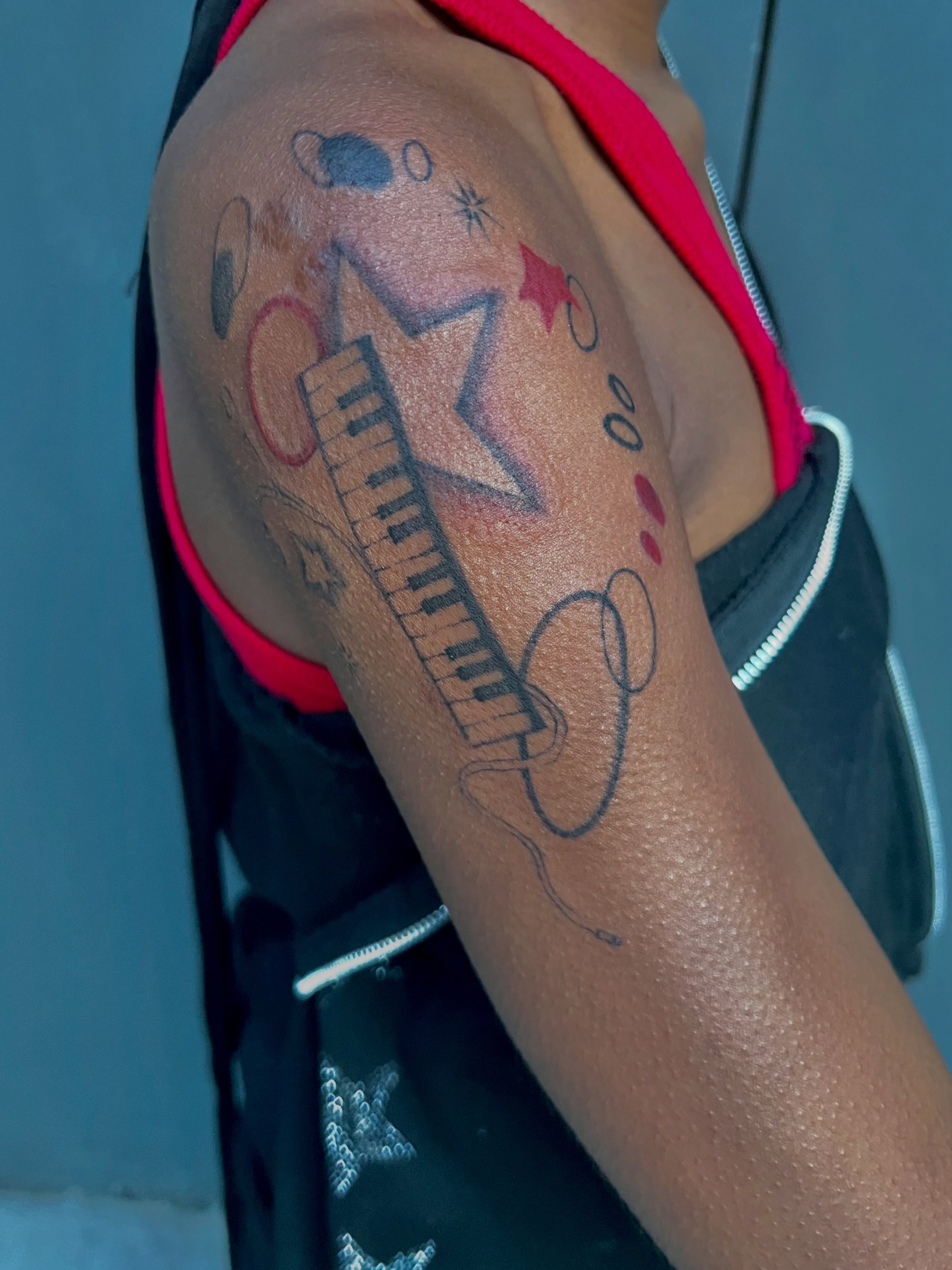 Keyboard and musical notes geometric tattoo on the upper arm by Haiiitattoo