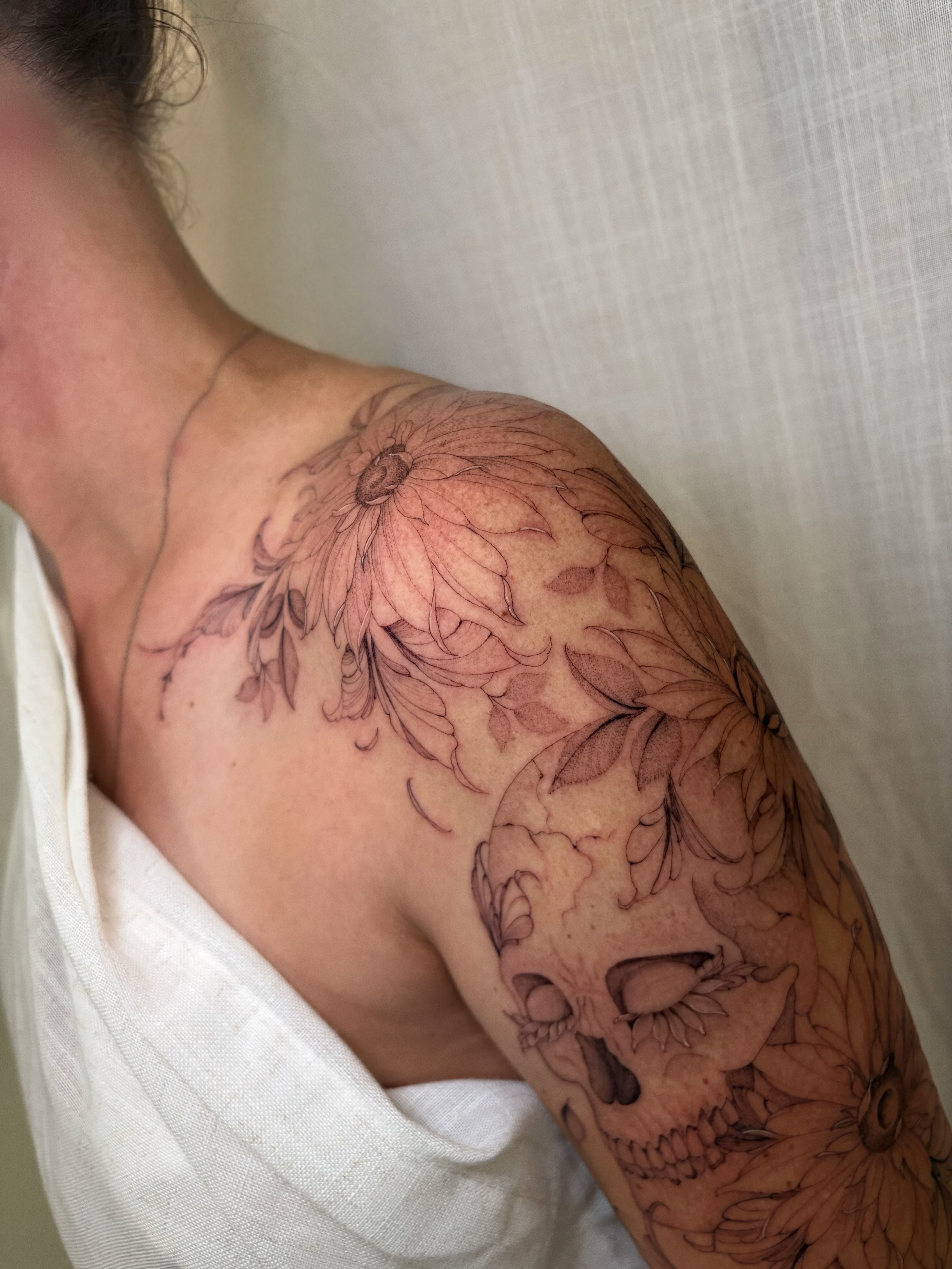 Skull and floral realism tattoo on the shoulder by Justene Renee 🖤 Fine Line Tattoo Artist