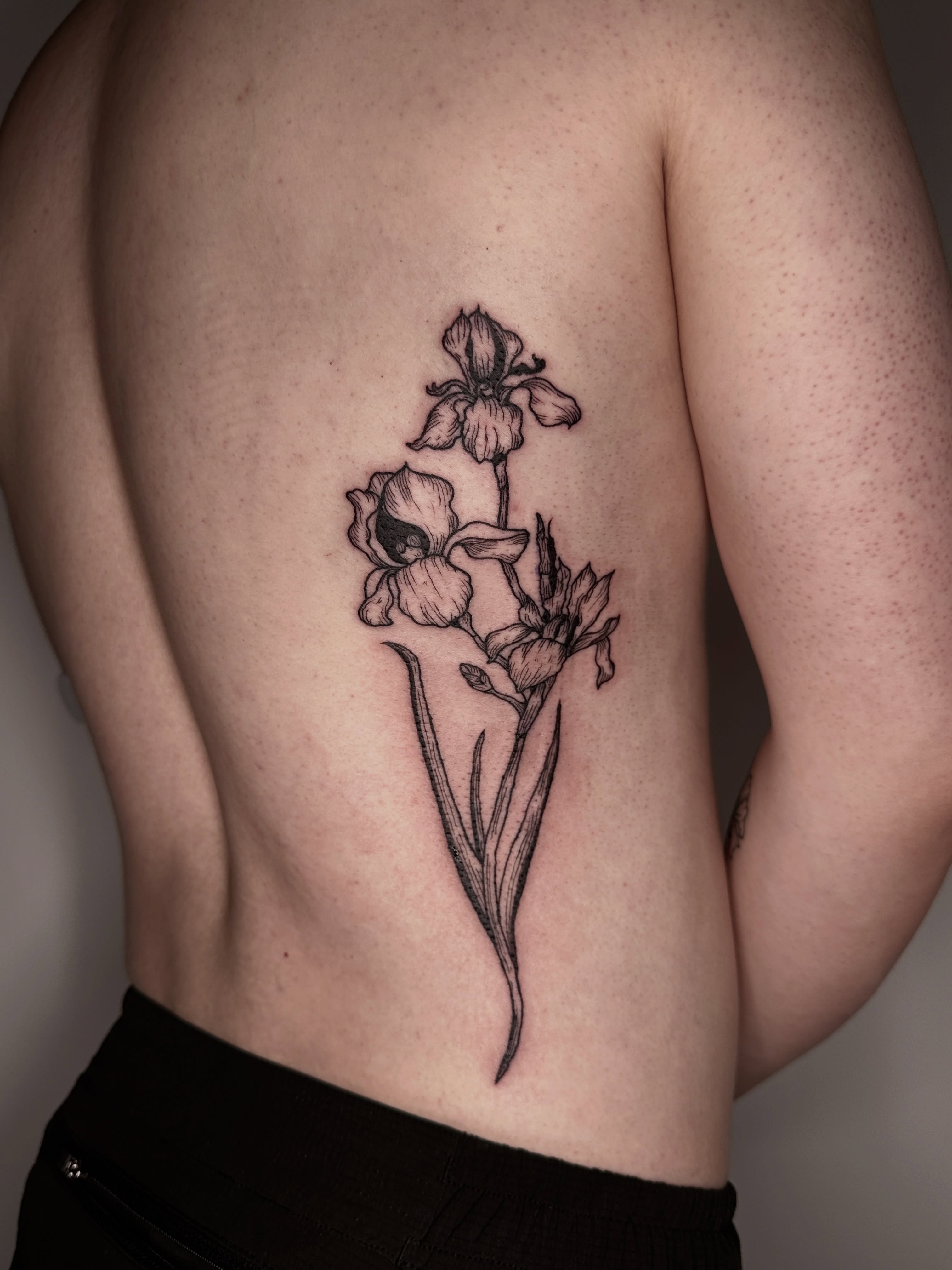 Iris flowers black and grey tattoo on the ribs by Zecember