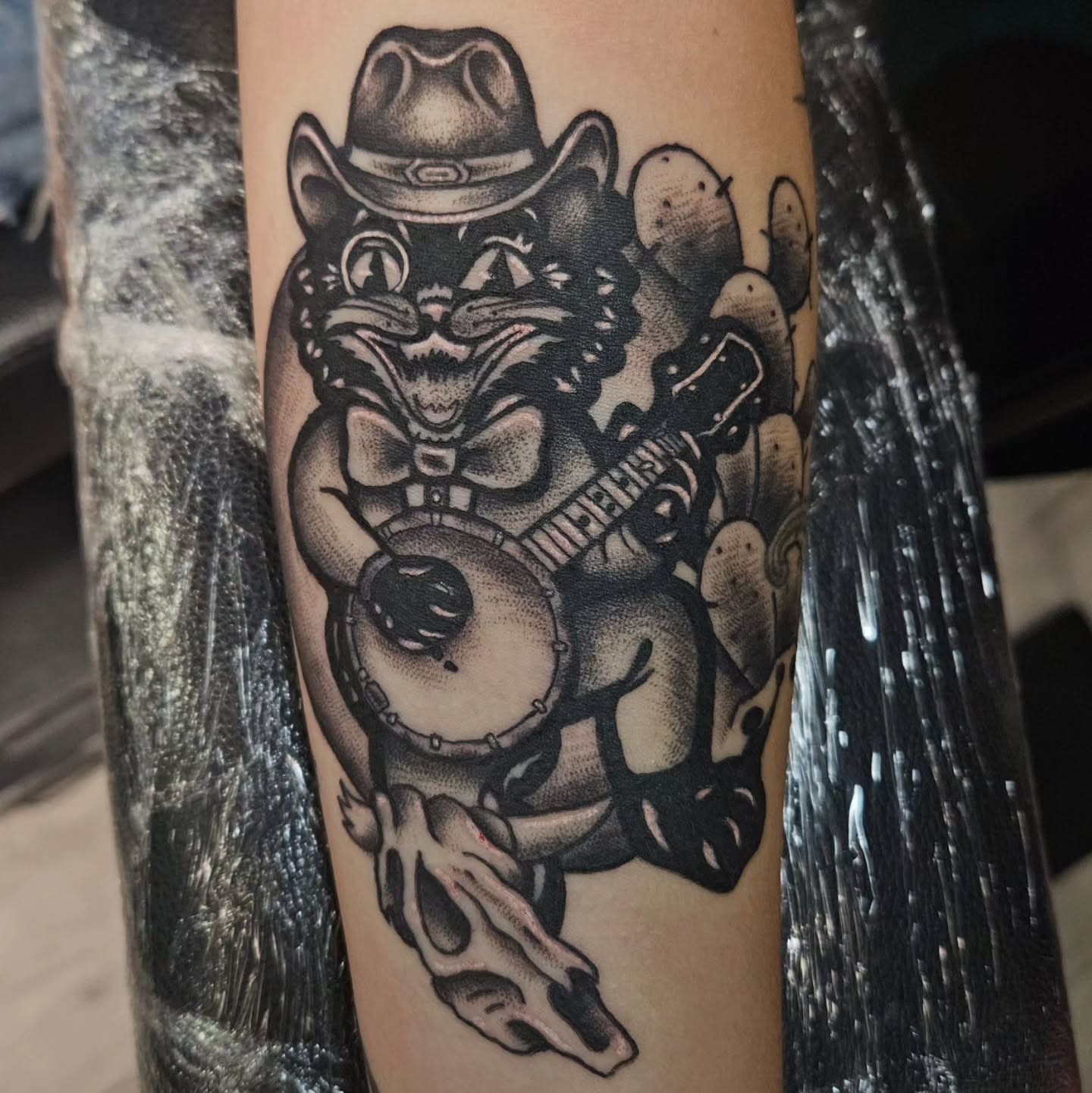 Cat playing banjo American traditional tattoo on the forearm by Ari🖤