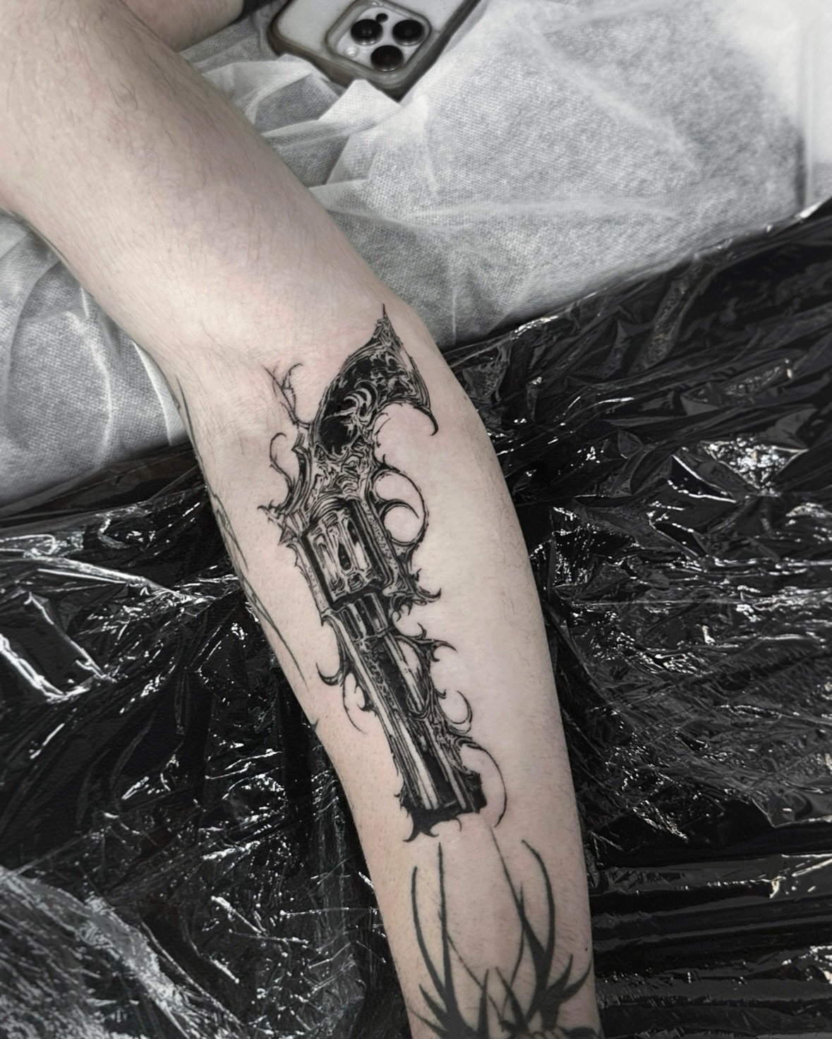 Gun with ornate details ornamental tattoo on the forearm by Gun