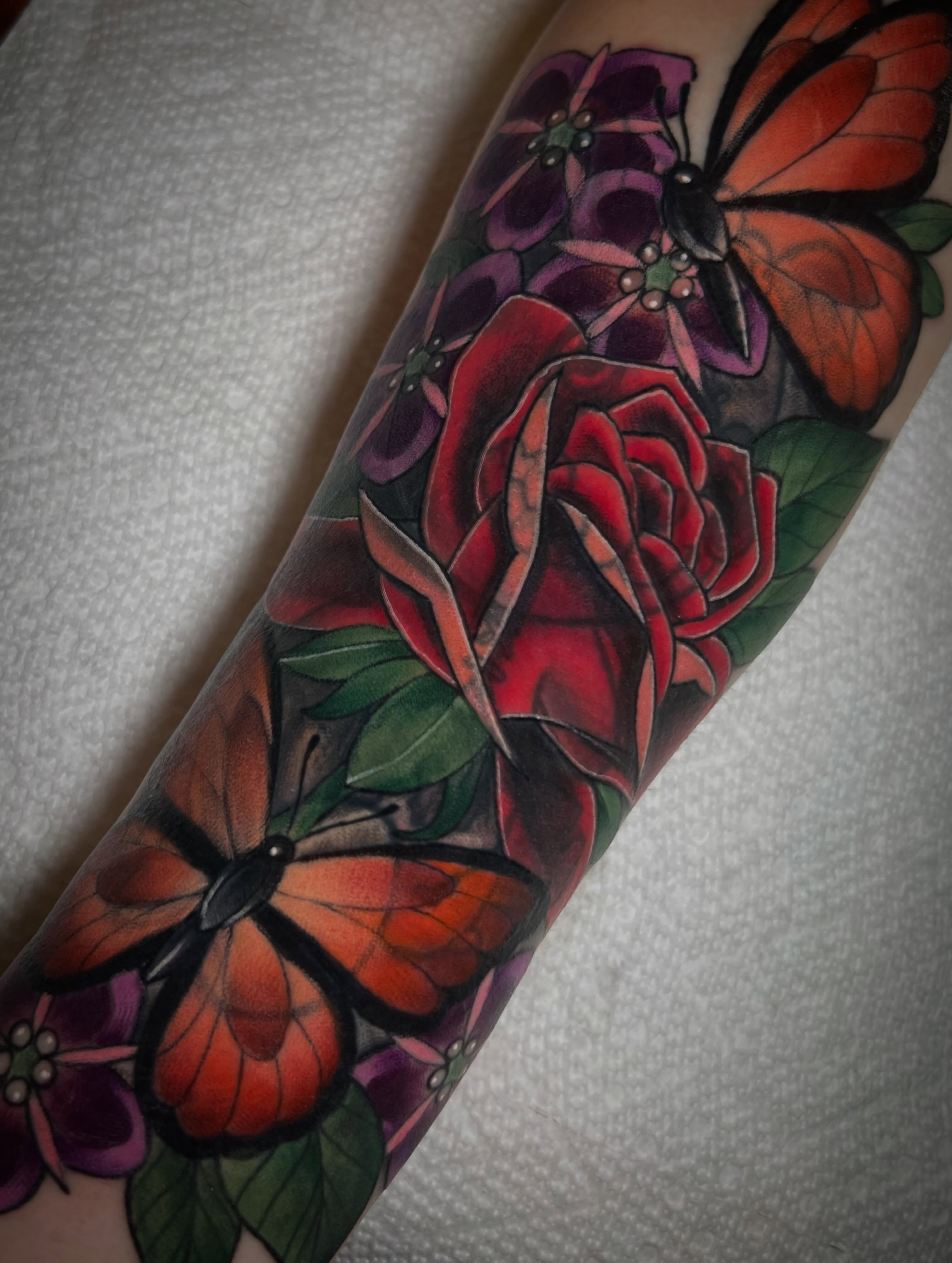 Butterfly and roses realism tattoo on the forearm by Katie Ann Tattoos
