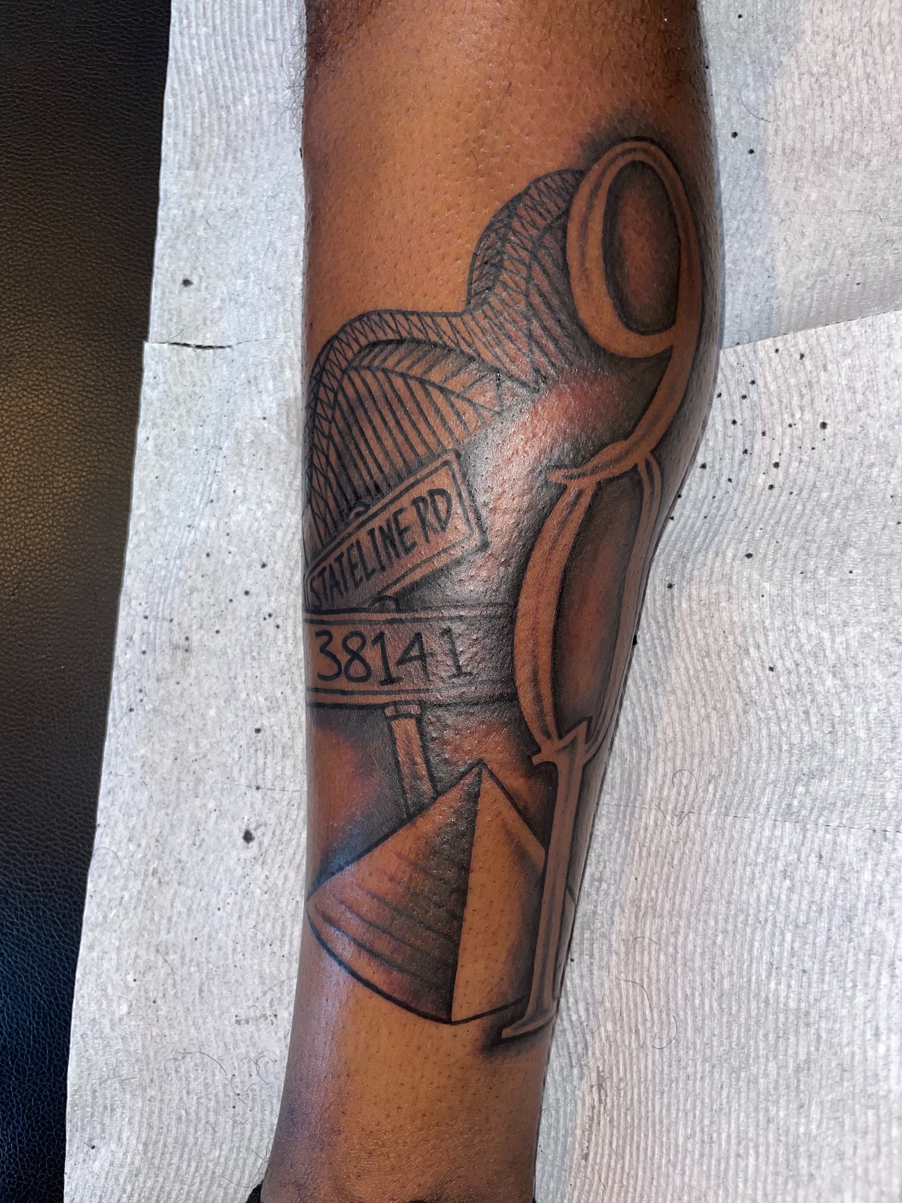 Hourglass and road sign black and grey tattoo on the forearm by TreCashTats💉🩸 MisfitzTattooStudio