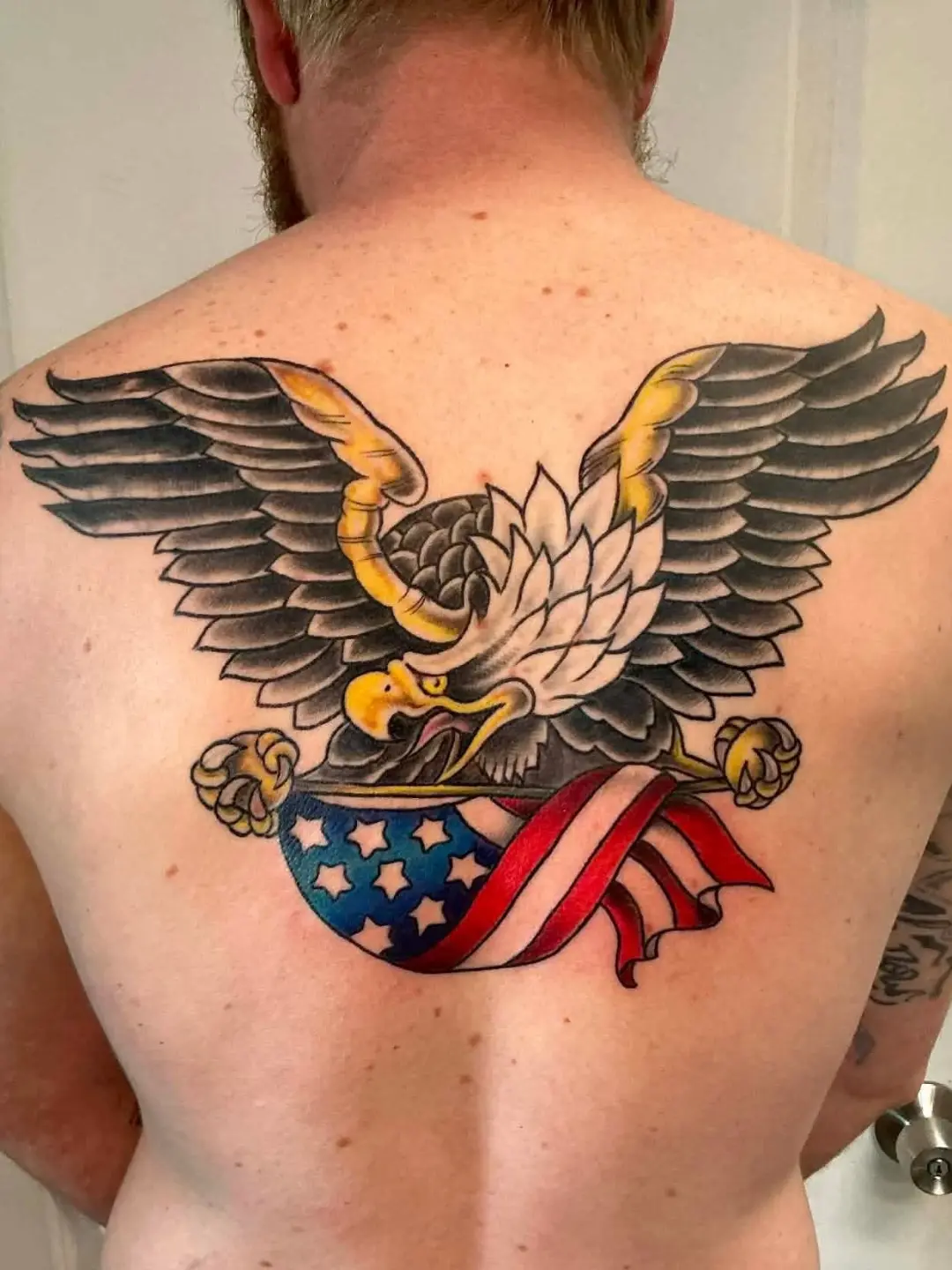 Eagle with American flag American traditional tattoo on the back by Rando Rad